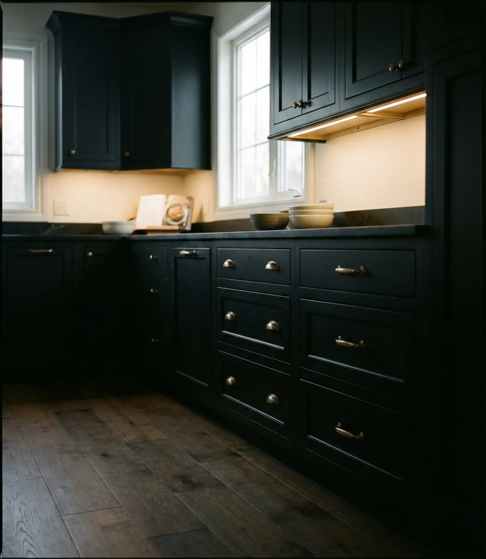 Black Cabinets with Brass Handles and Warm Lighting 2