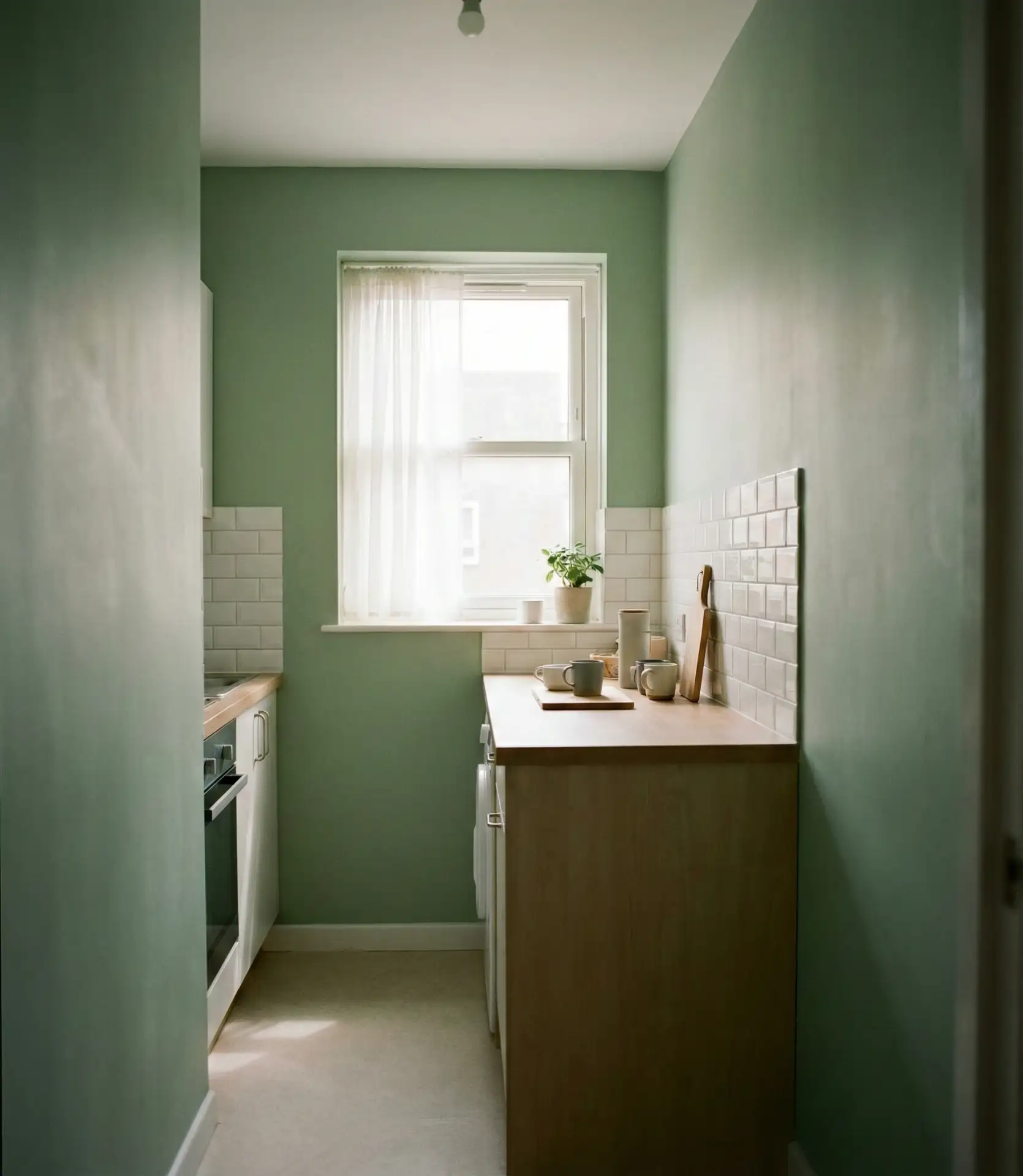 Pastel Sage Walls in a Small Apartment Kitchen 1