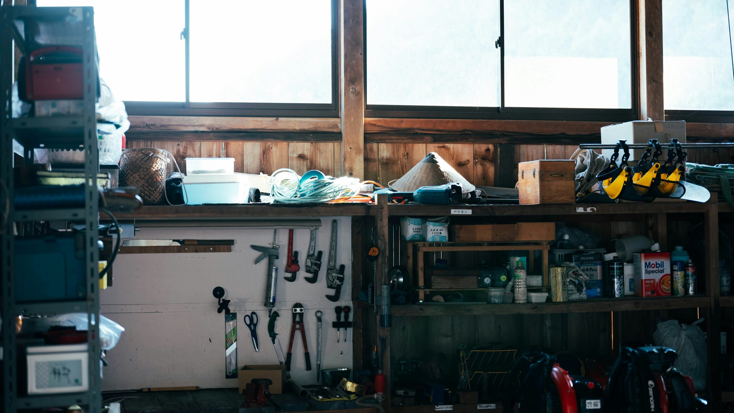 A cluttered workshop shelf with tools and supplies.