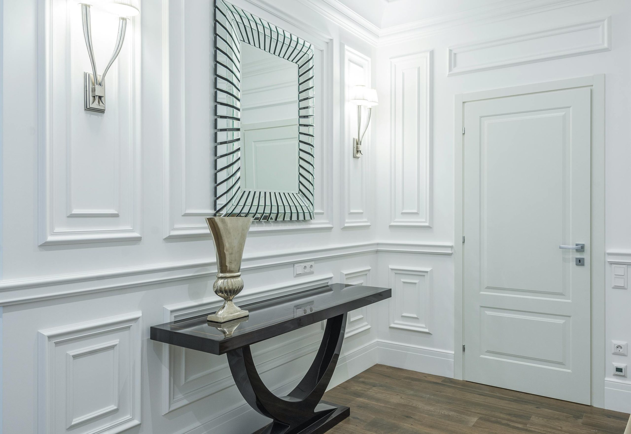 A stylish hallway interior with modern decor, featuring a sleek mirror and elegant console table.