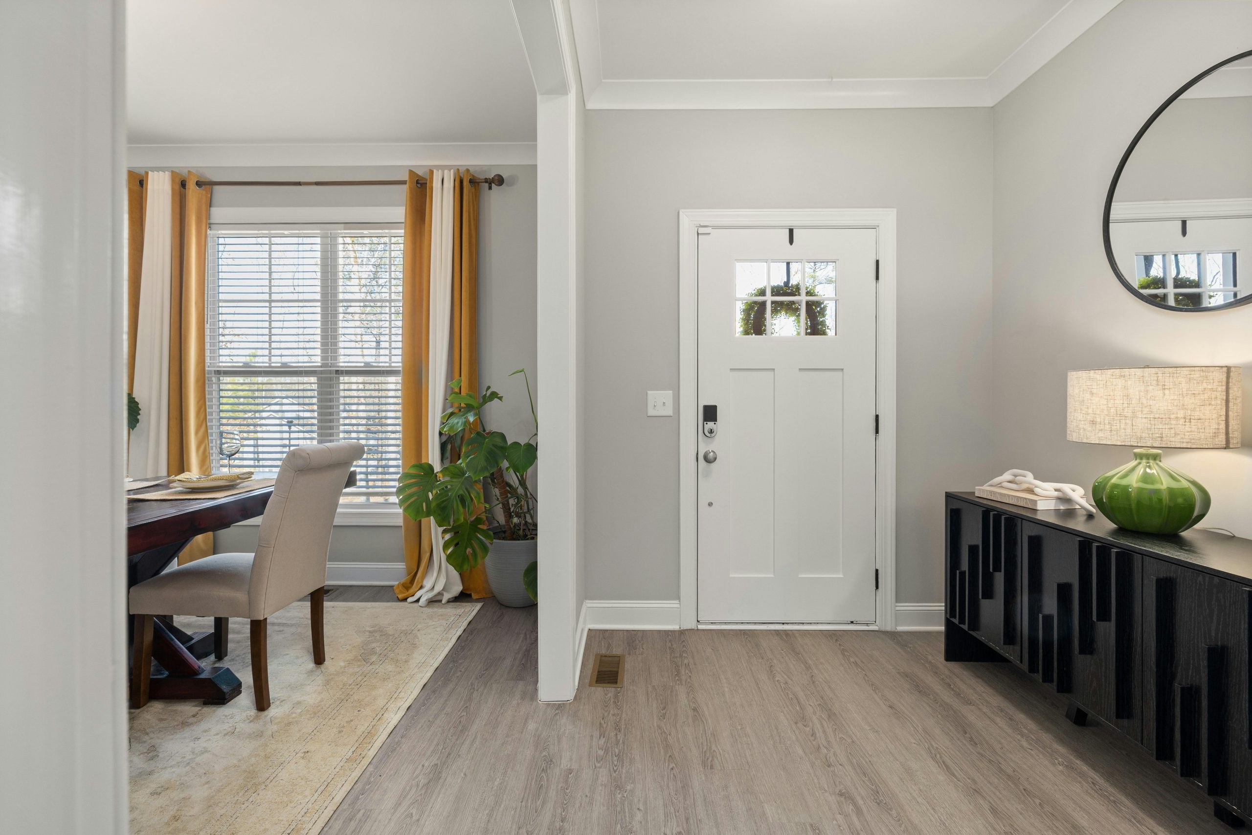 Bright entryway featuring elegant furniture, plants, and natural light.