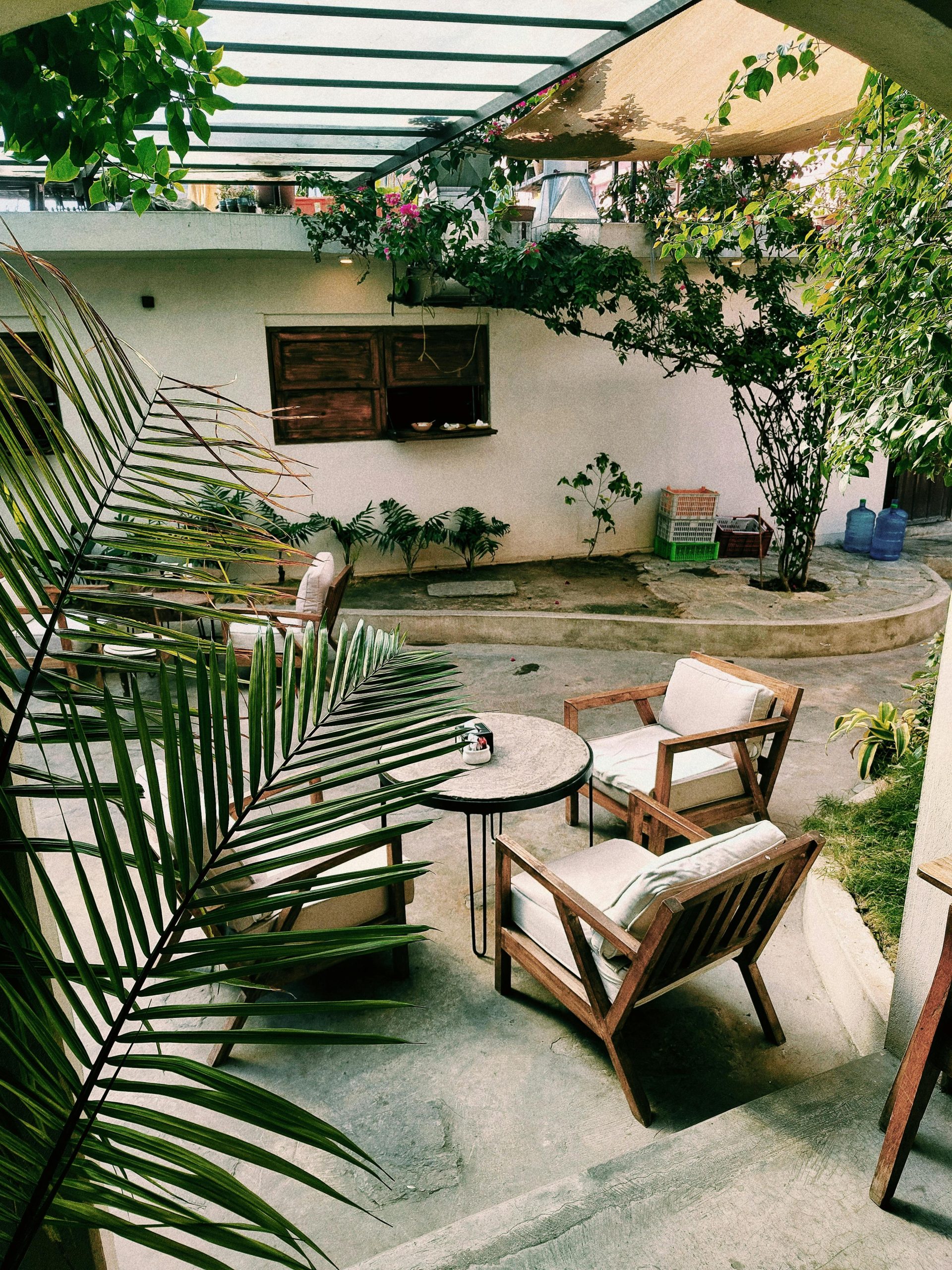 Charming outdoor patio with wooden furniture and lush greenery, perfect for relaxation.