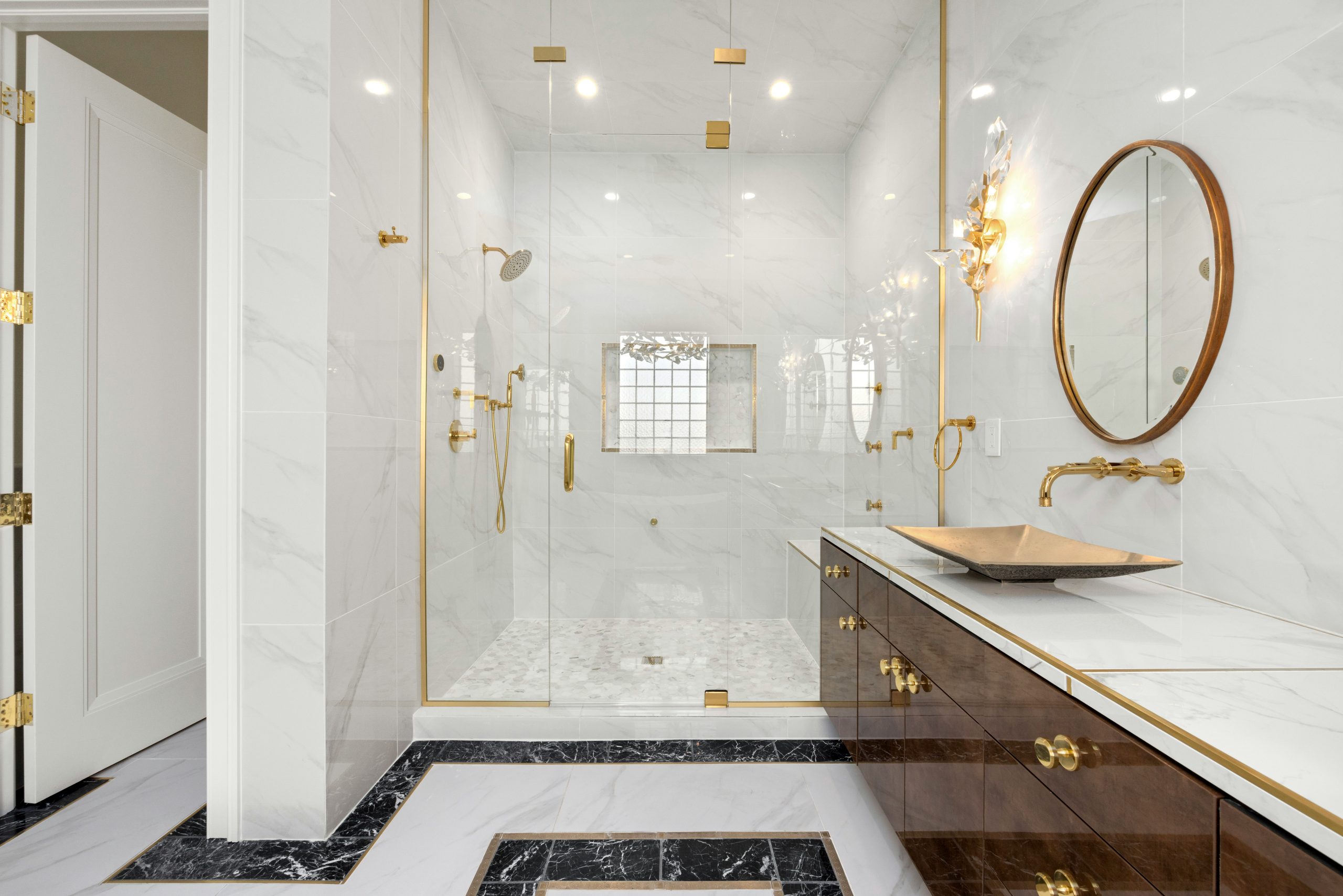 a bathroom with a marble counter top and gold accents