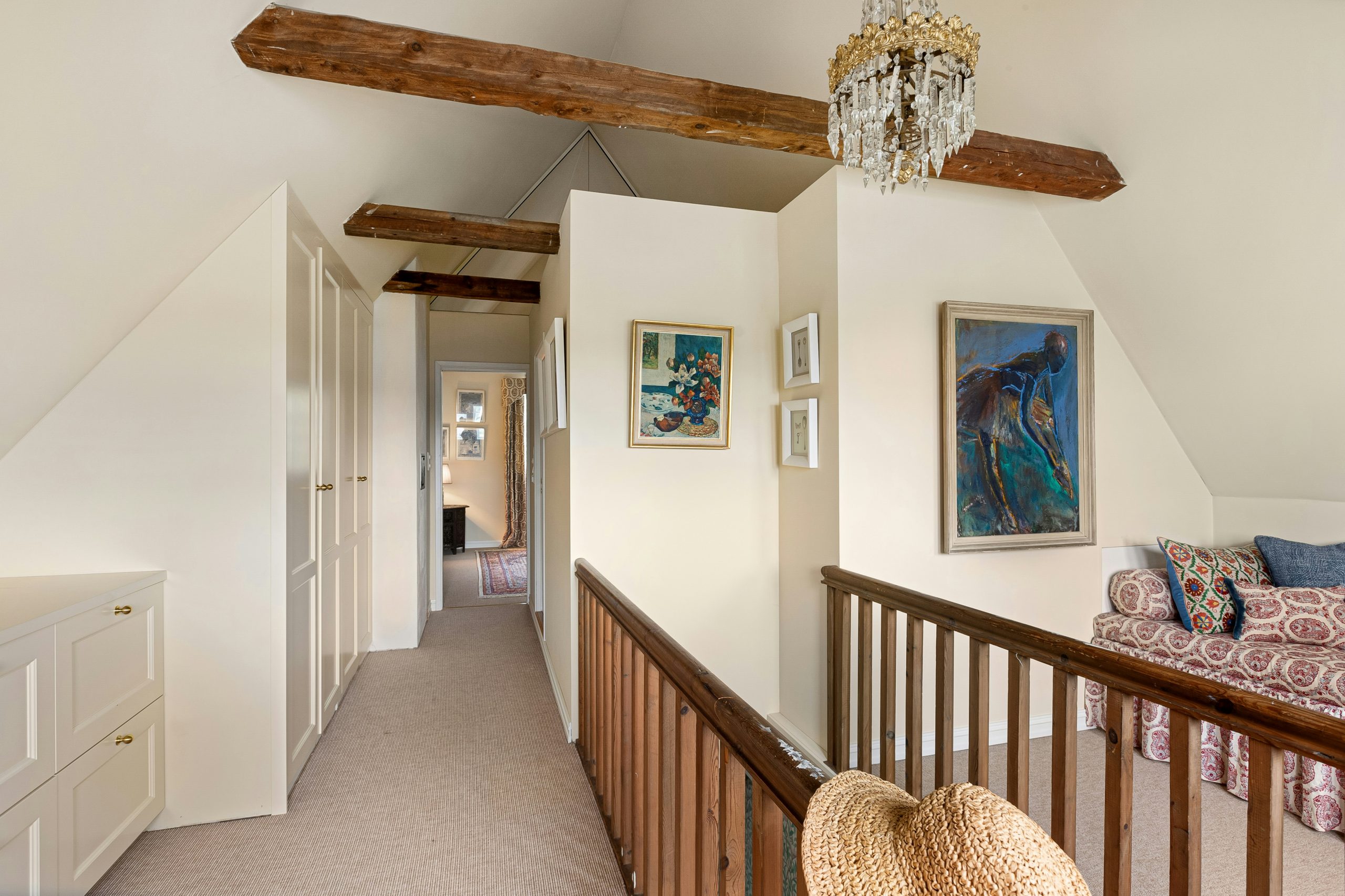 A room with a bed, a couch and a chandelier