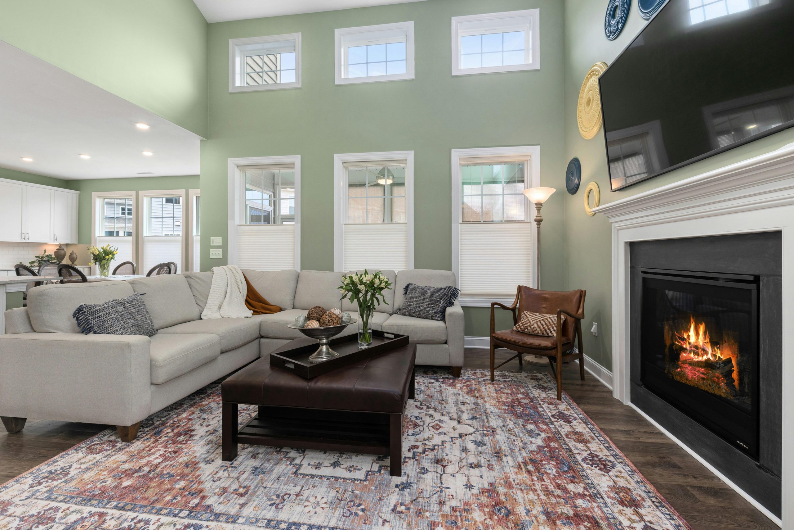 A stylish living room featuring a fireplace, sectional sofa, and natural light.