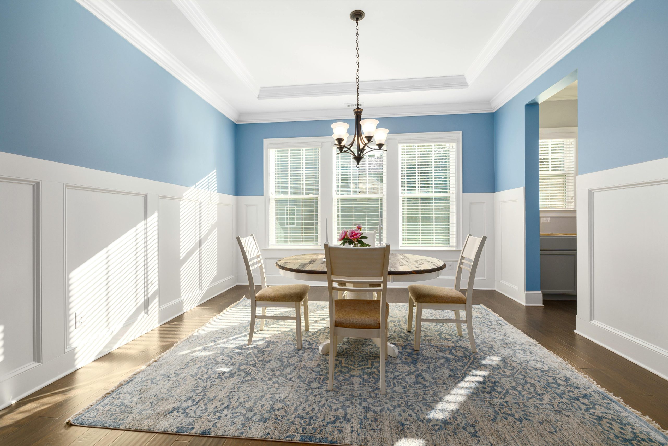 Bright dining room with blue walls, elegant decor, and abundant natural light.
