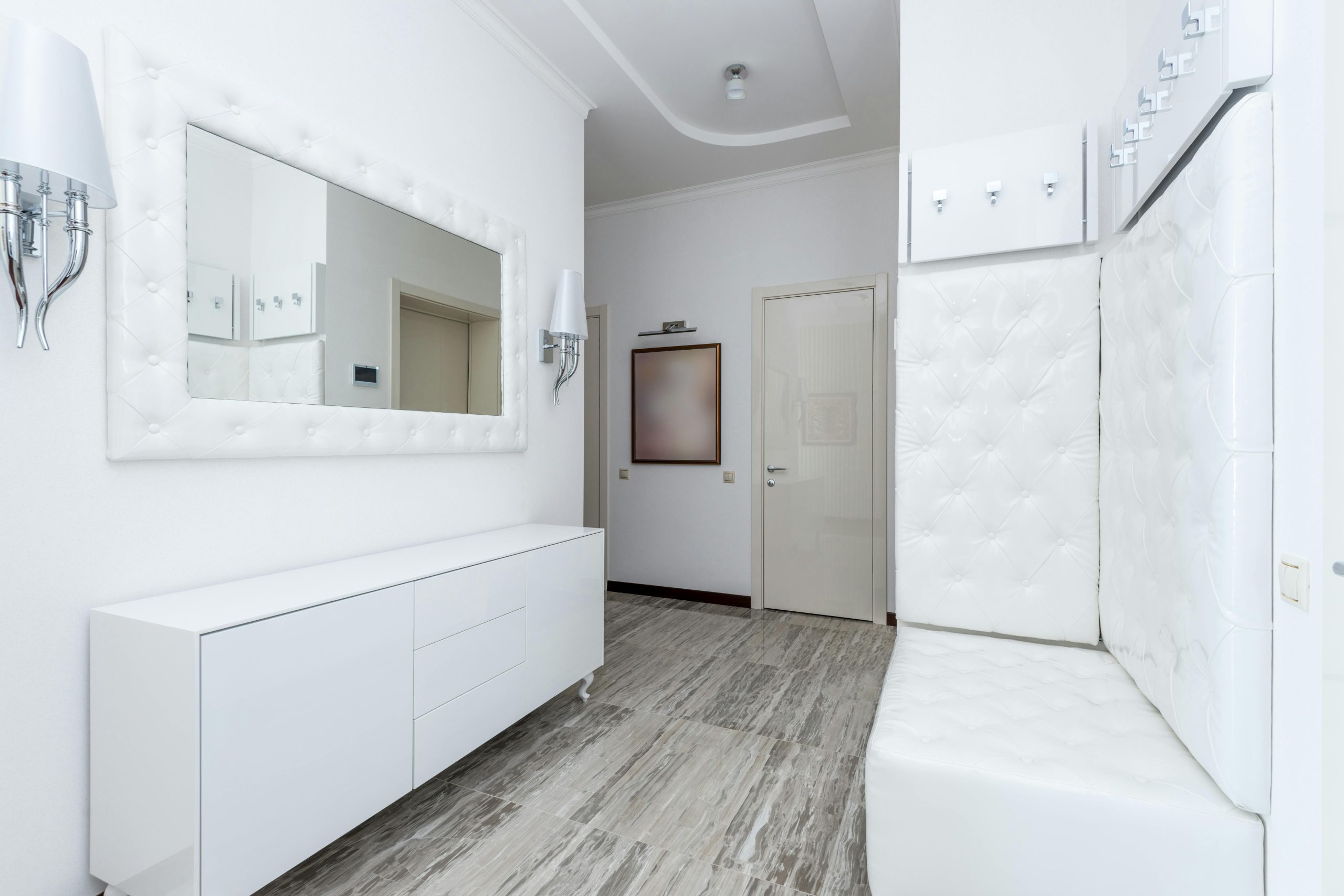 Bright minimalist hallway interior with white decor and modern furniture.