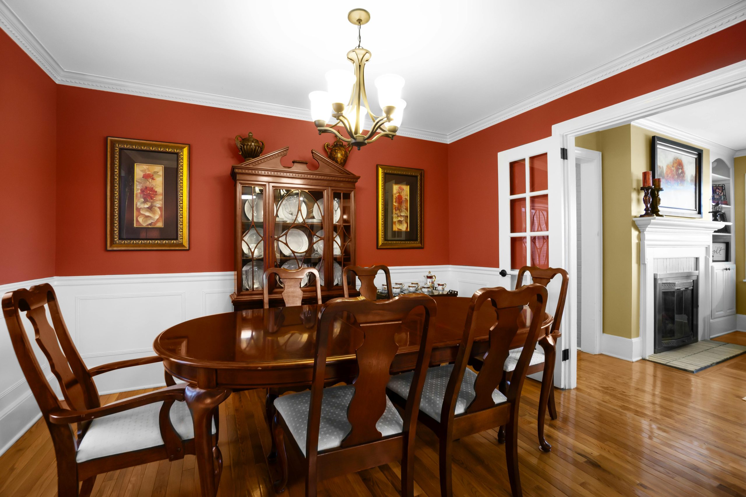 Charming dining room featuring elegant wooden furniture and a classic chandelier.