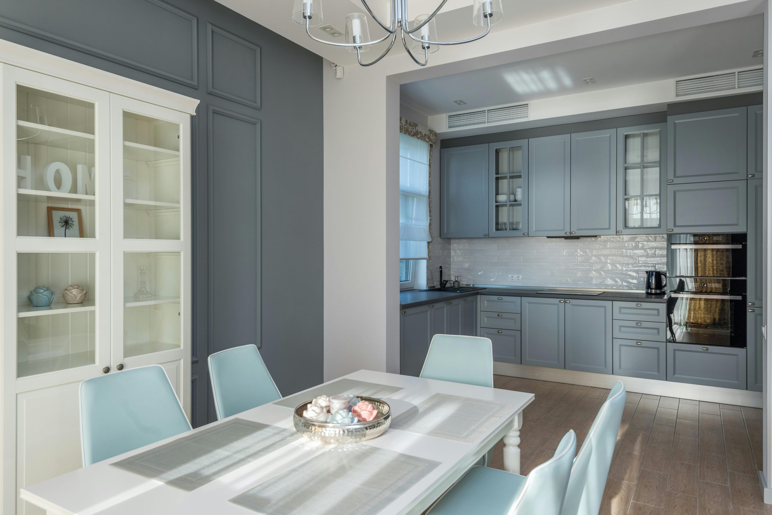 Chic dining room with pastel chairs and grey kitchen cabinets. Perfect for modern interior design inspiration.