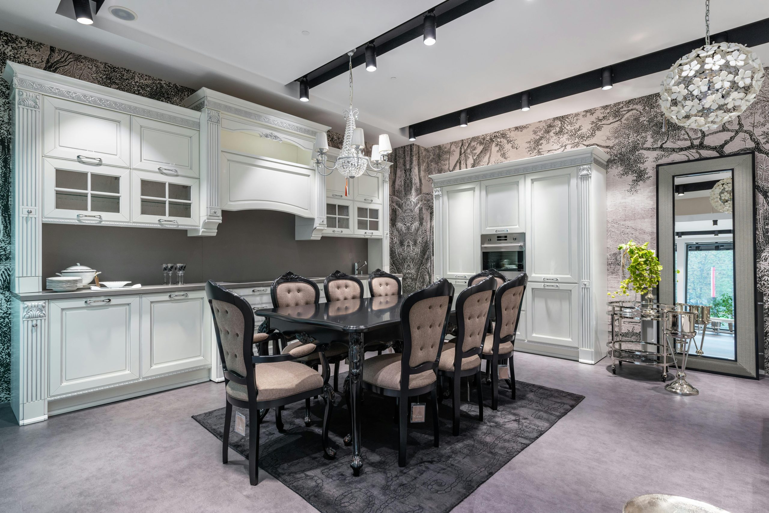 Interior of design of kitchen in classical style with white wooden cupboard and dining table surrounded with chairs