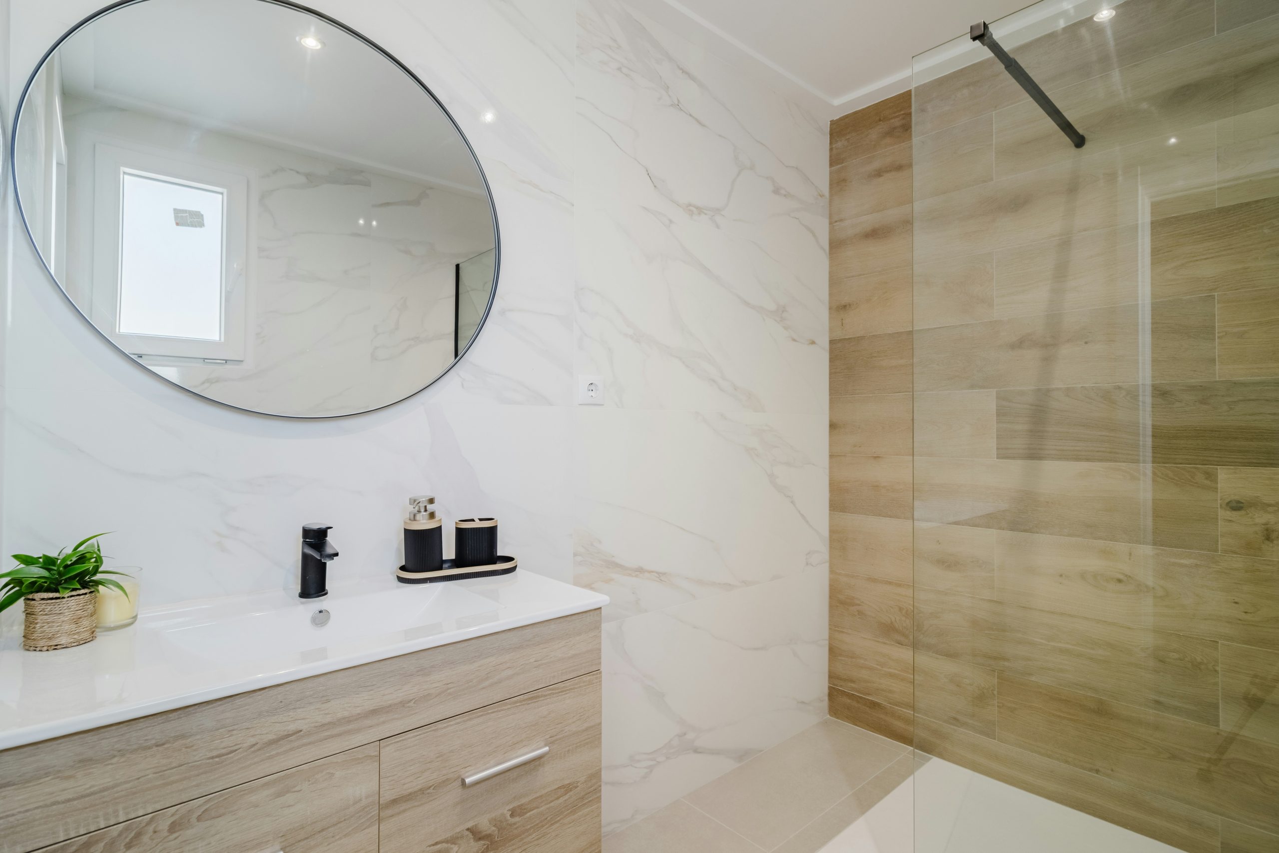 Modern bathroom with marble accents and walk-in shower.