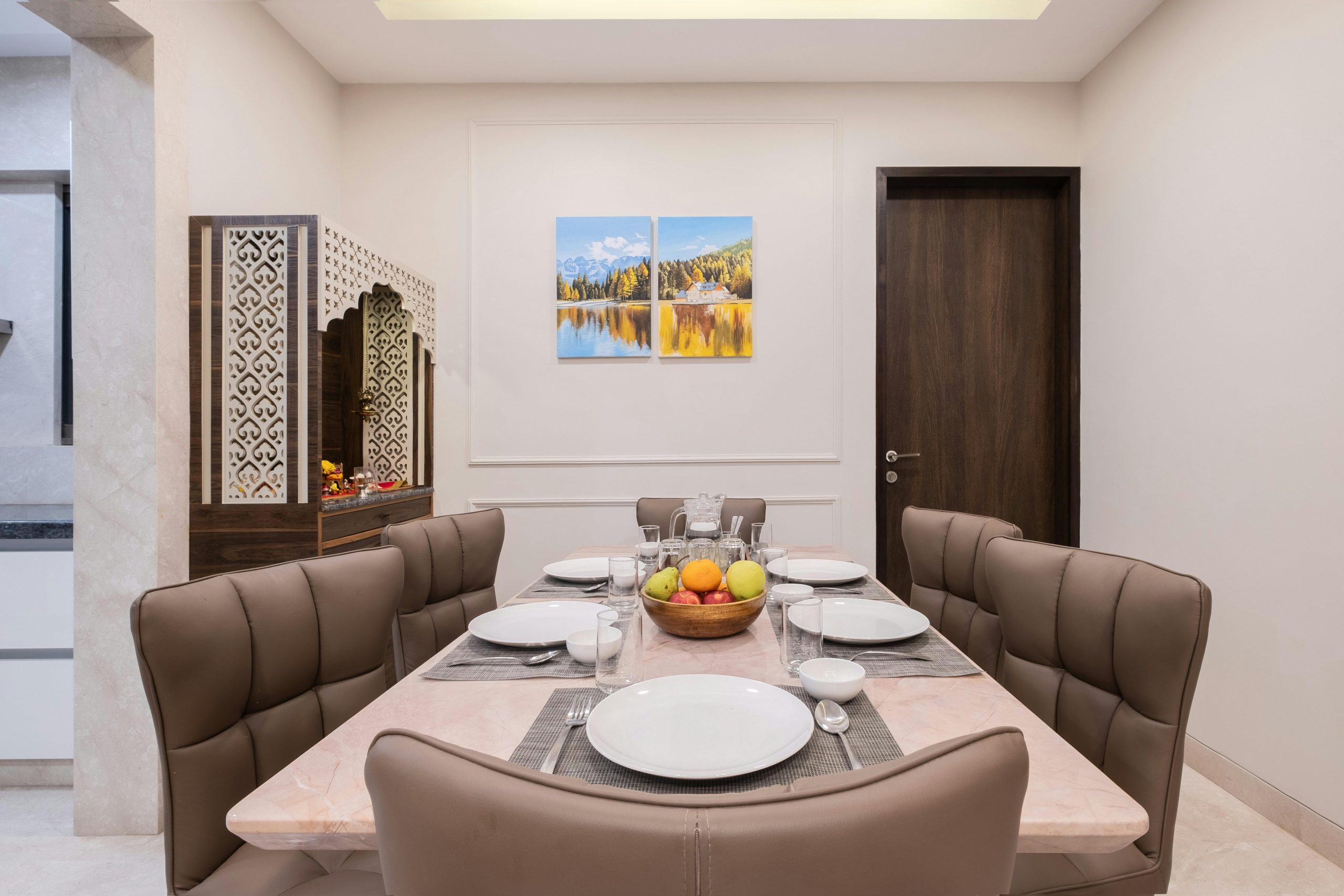 Modern dining room setup with elegant decor and a fruit centerpiece in Pune, India.