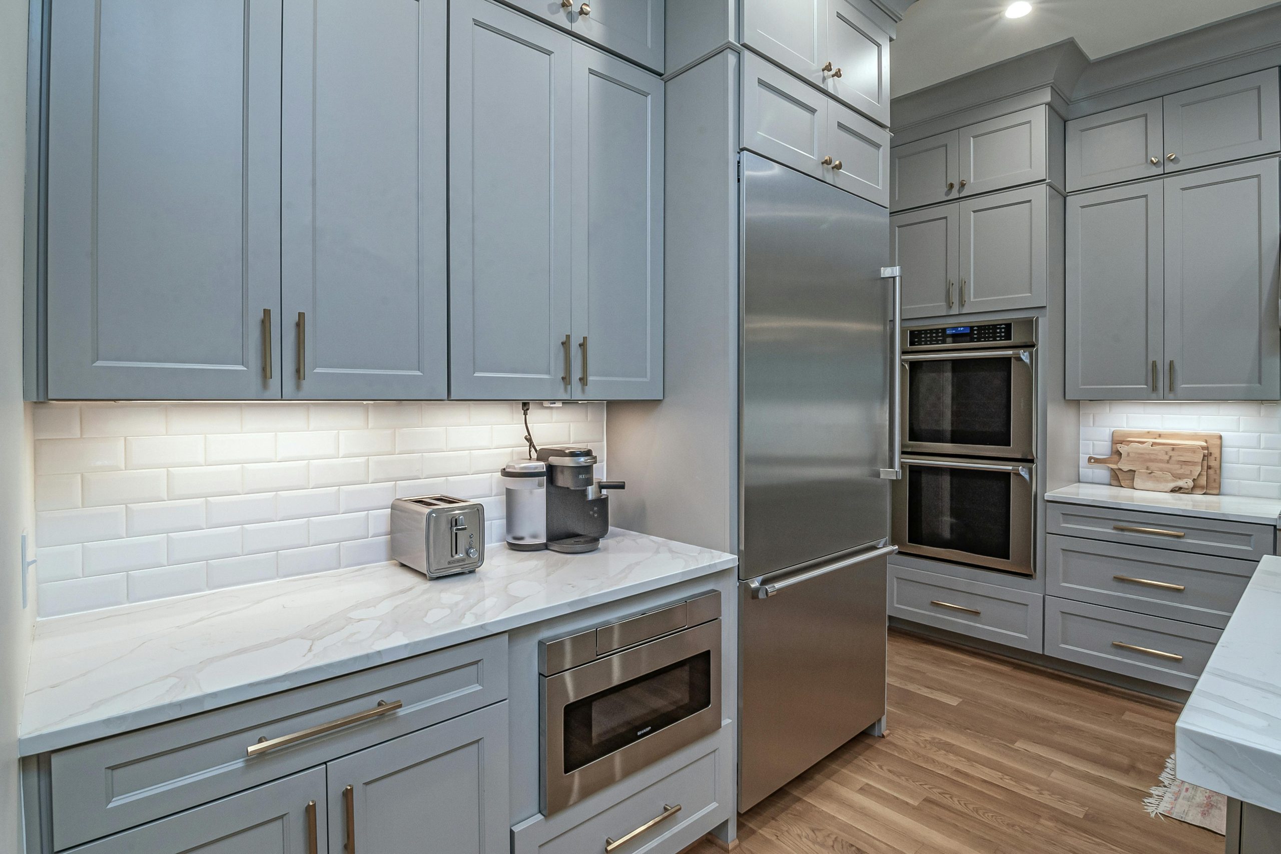 Sleek modern kitchen featuring stainless steel appliances and light grey cabinets.
