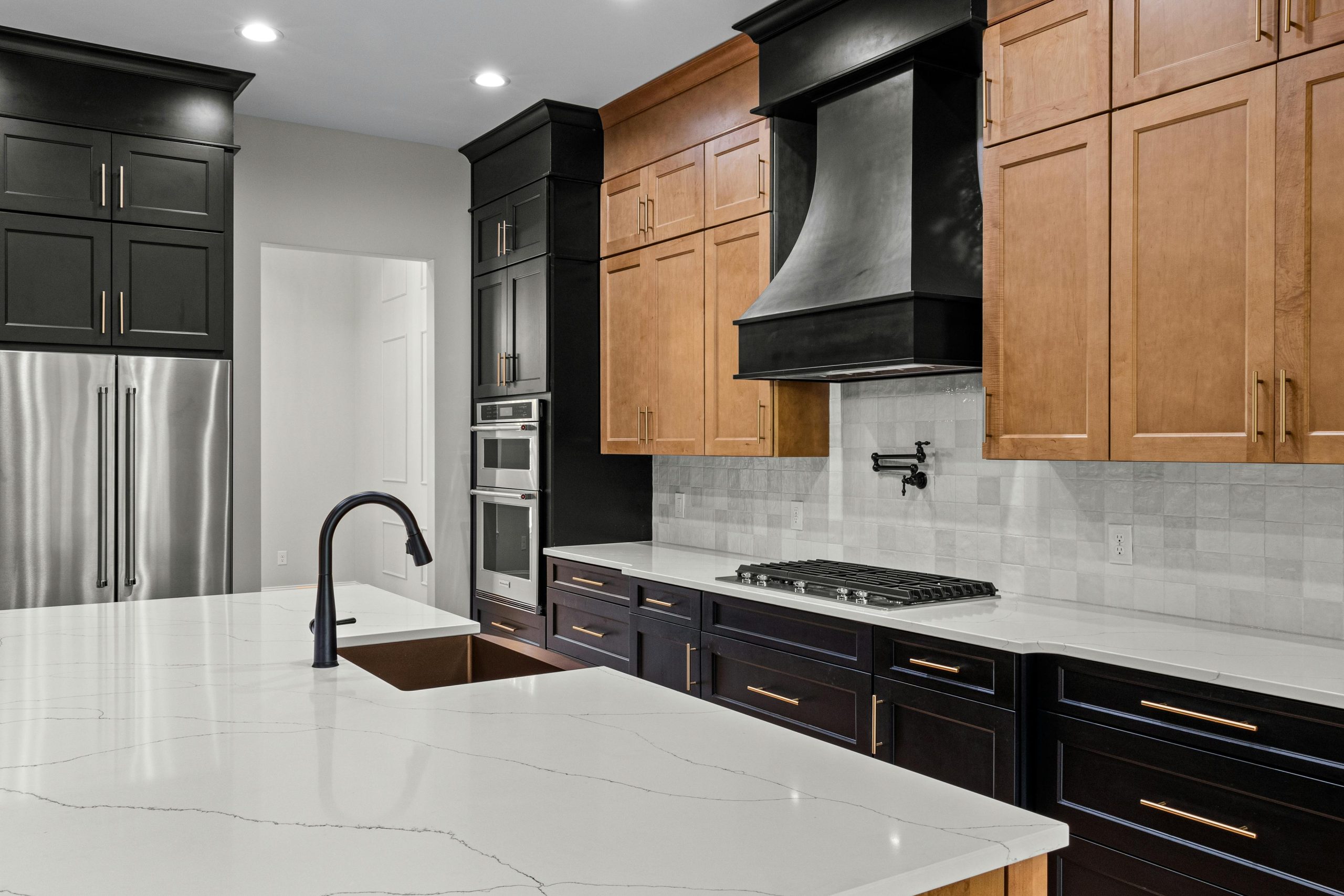 Sleek modern kitchen featuring wooden and black cabinetry with stainless steel appliances.