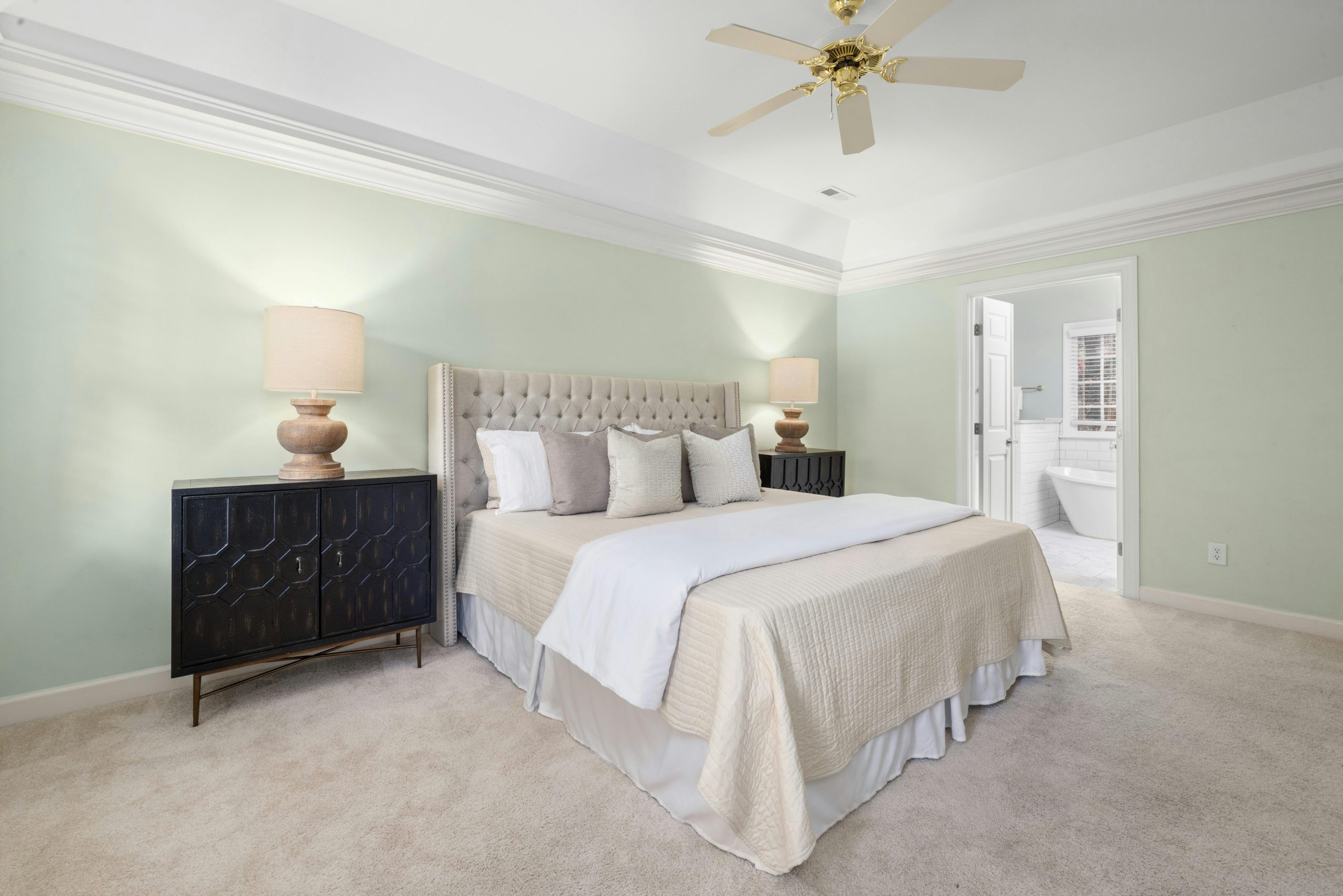 Spacious and bright bedroom featuring a king-sized bed, twin lamps, and stylish decor.