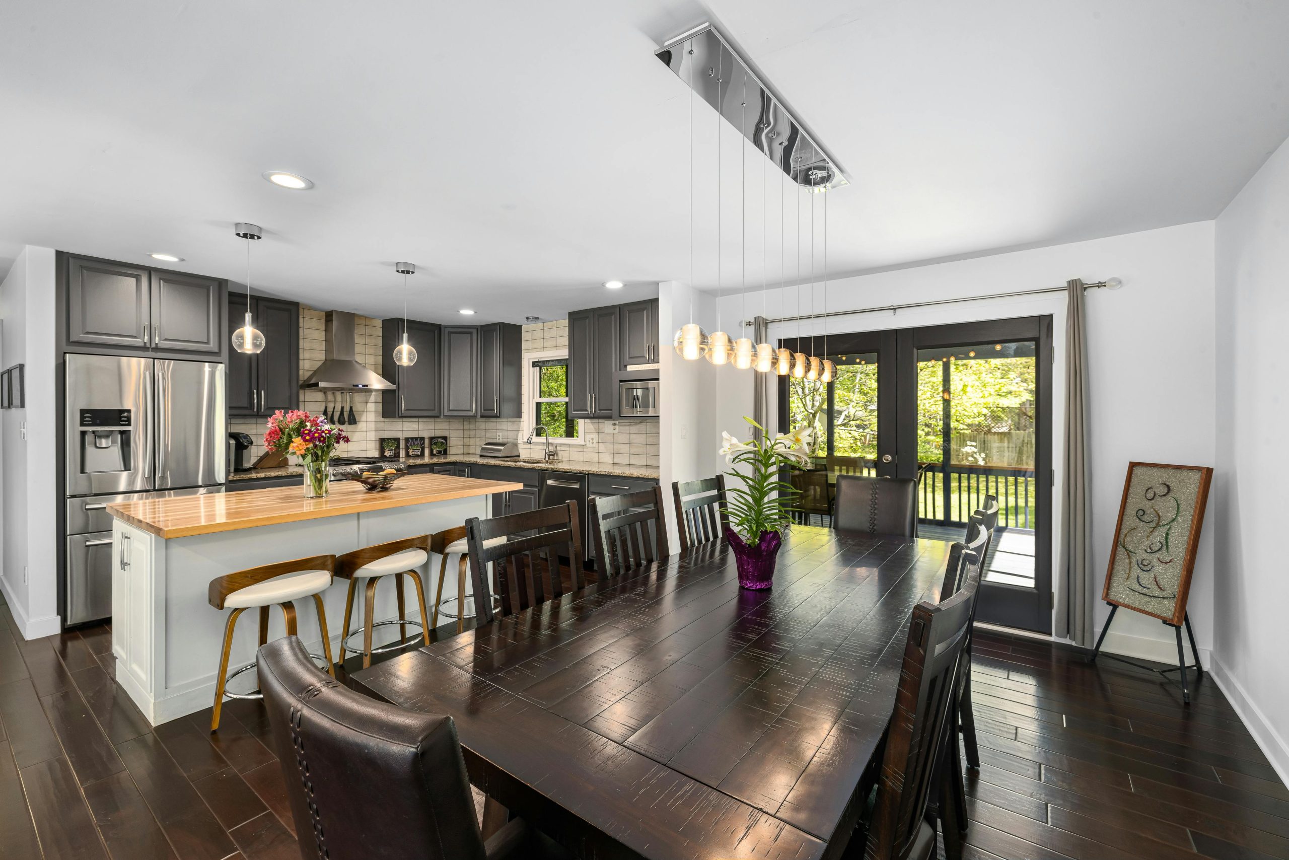 Spacious kitchen with dining room, modern decor, and natural light.