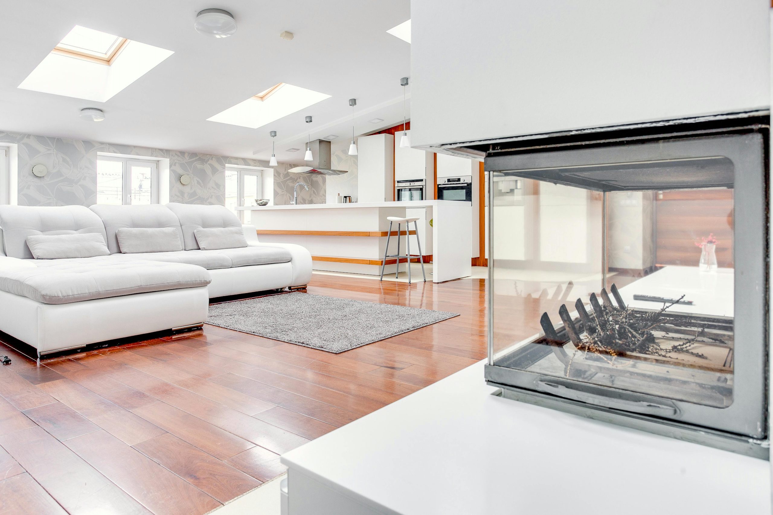 Spacious loft interior with sleek design featuring a fireplace and skylight.