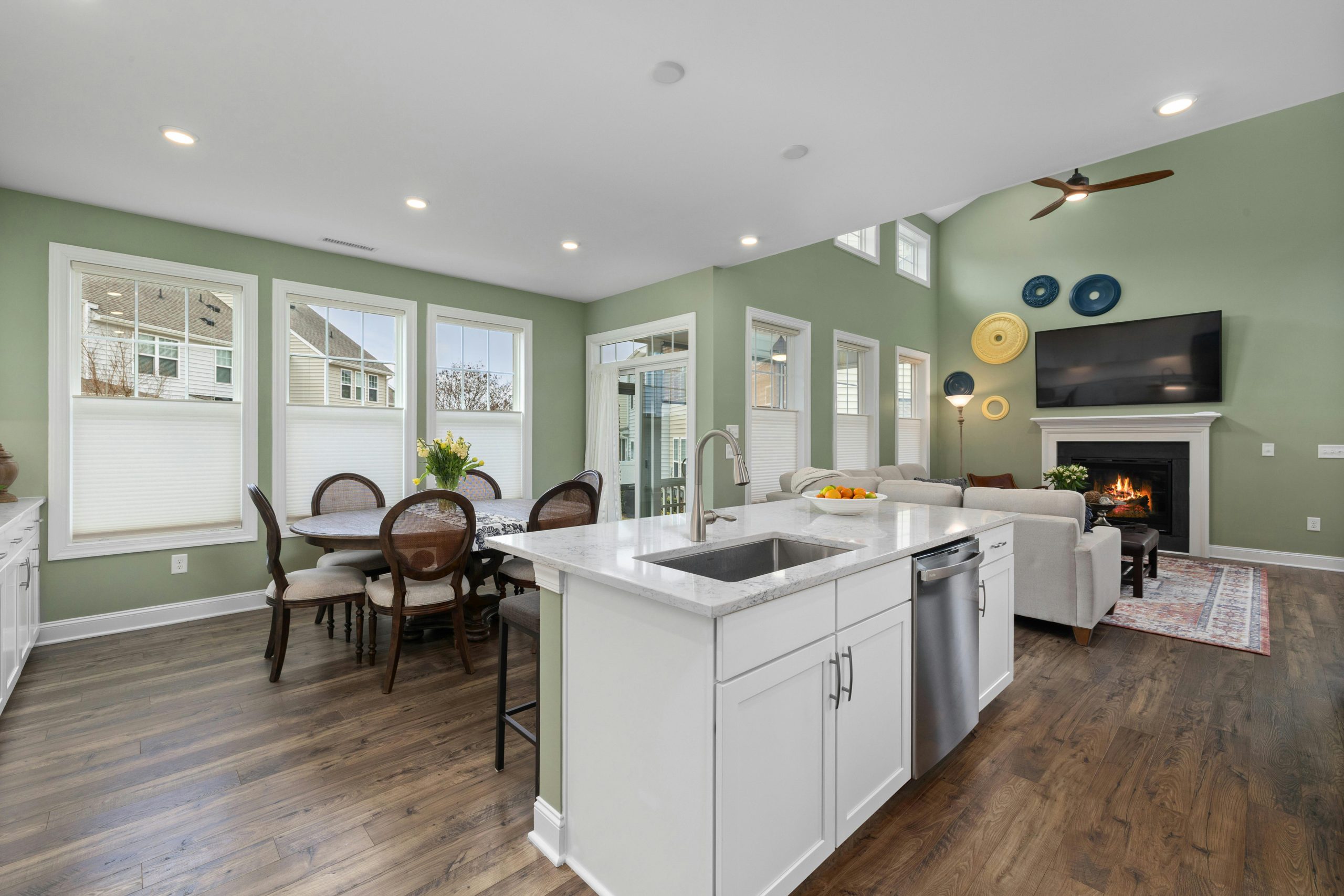 Spacious open-concept living area with a modern kitchen, dining space, and fireplace.