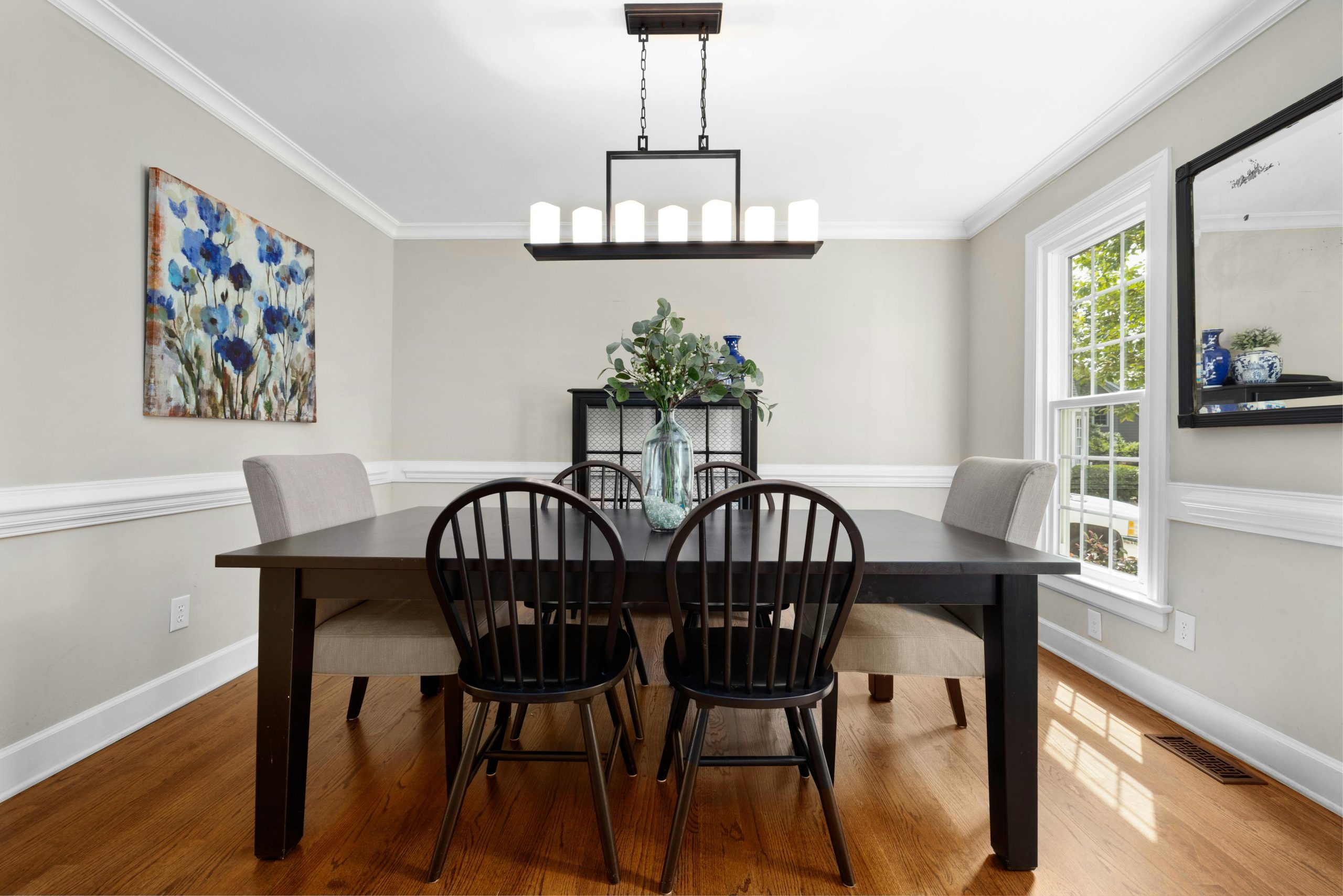 Stylish dining room featuring minimalist design, wooden table, and modern lighting.