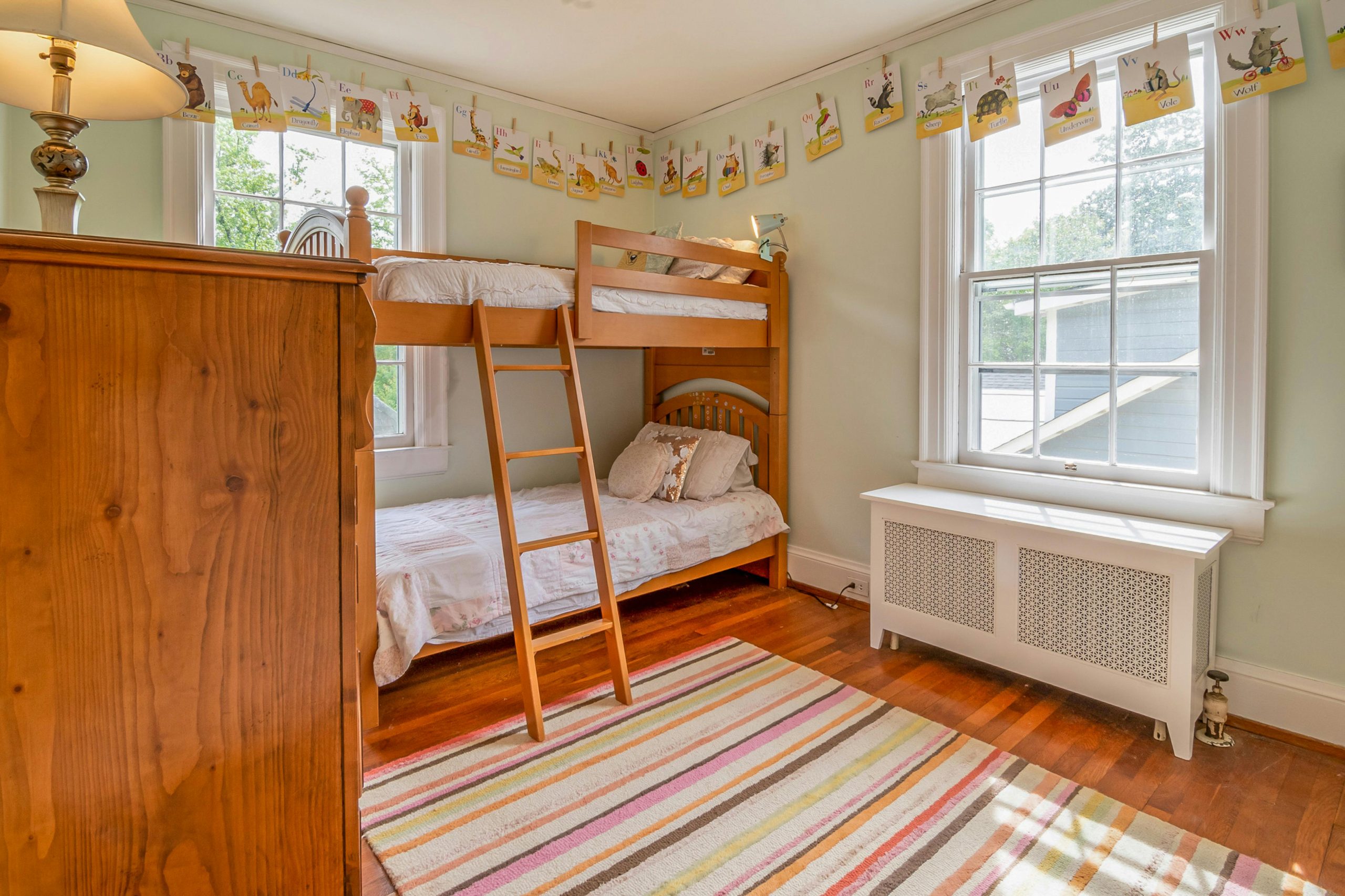 Warm and inviting children's bedroom featuring wooden bunk beds and ample natural light.