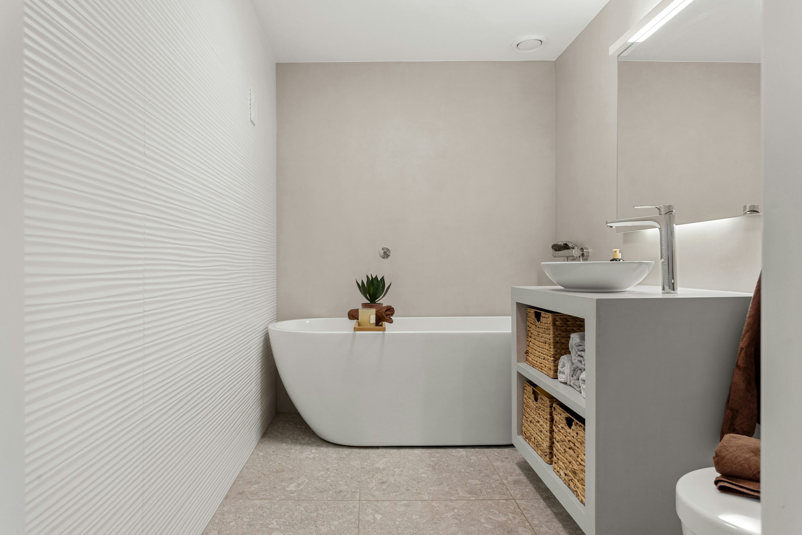 A bathroom with a white bath tub sitting next to a toilet