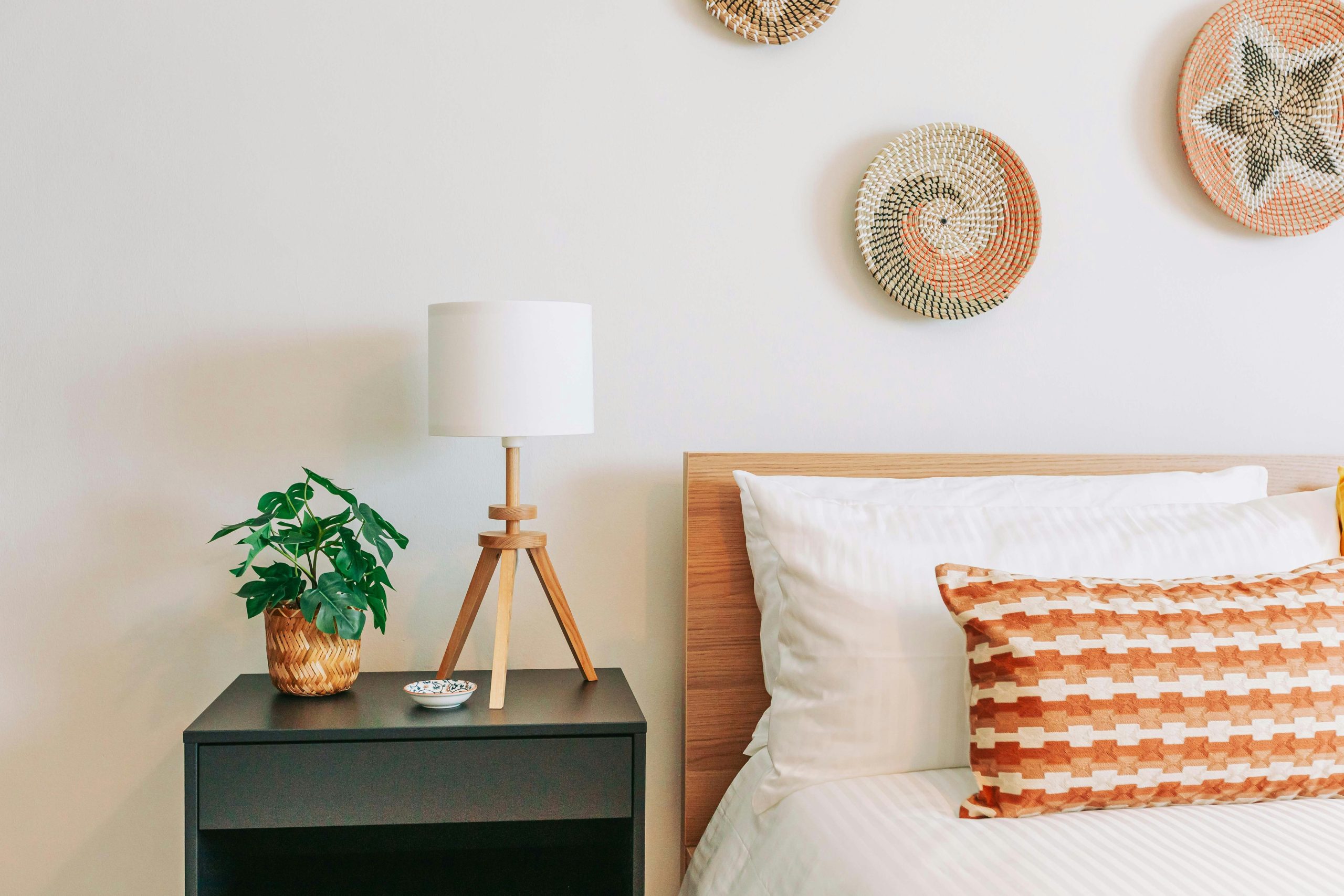 a bed room with a neatly made bed and a night stand