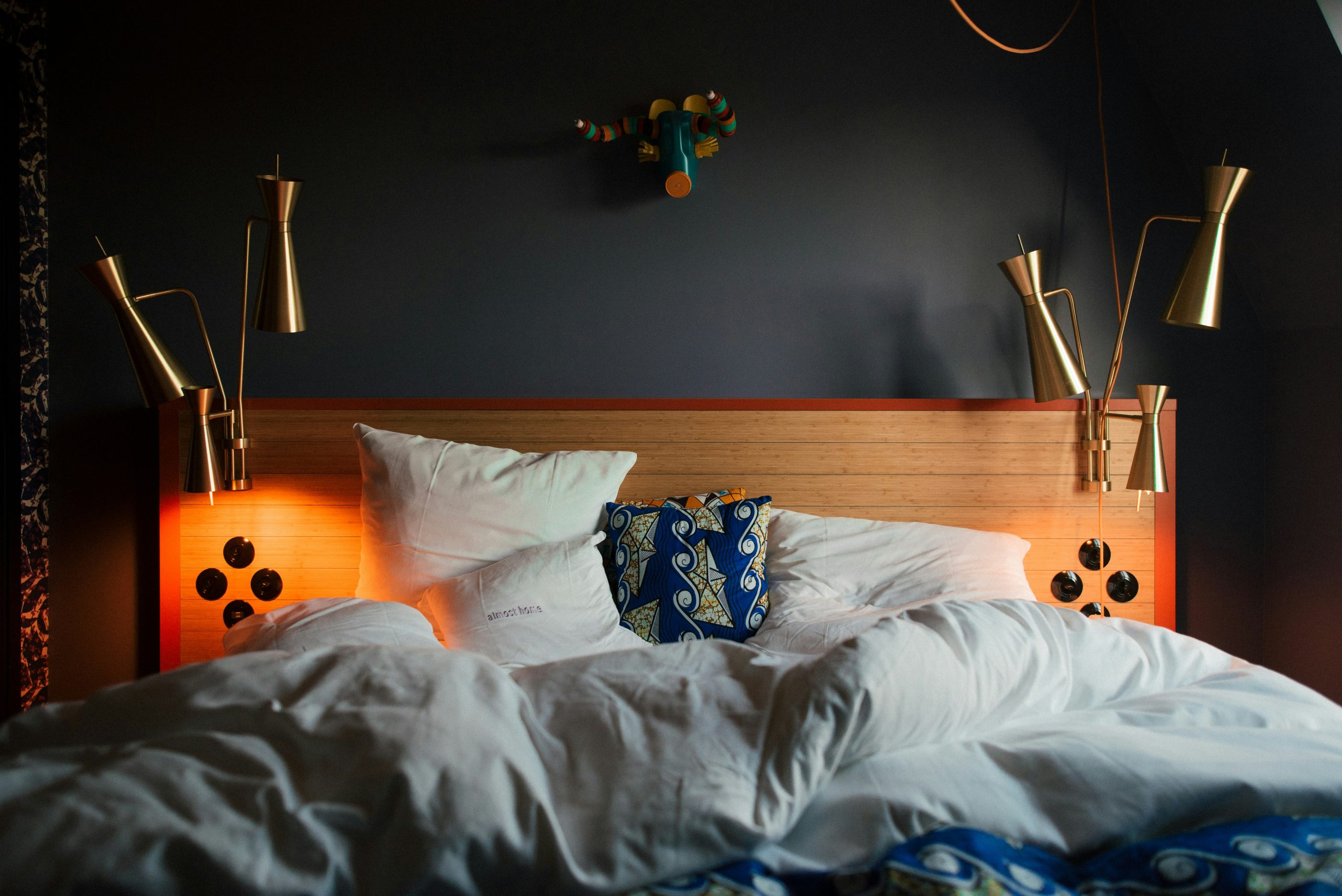 a bed with a white comforter and pillows