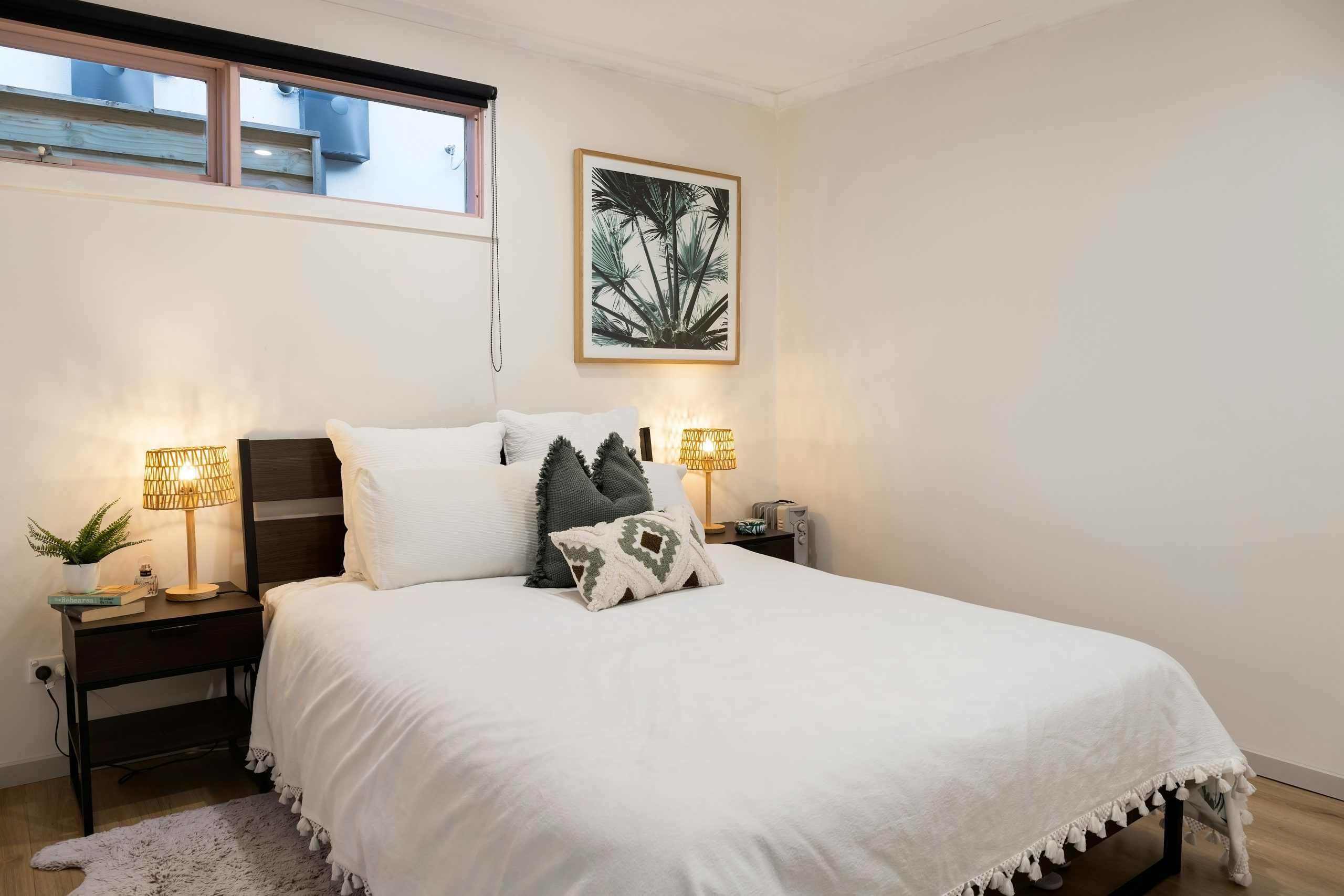 a bed with a white comforter and pillows