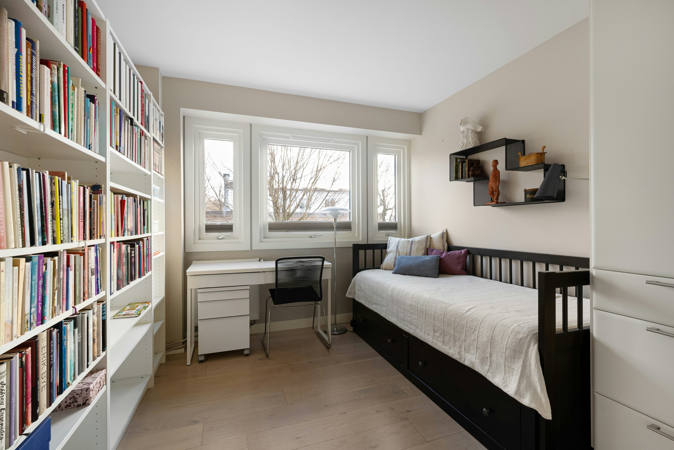 A bedroom with a bed and a book shelf