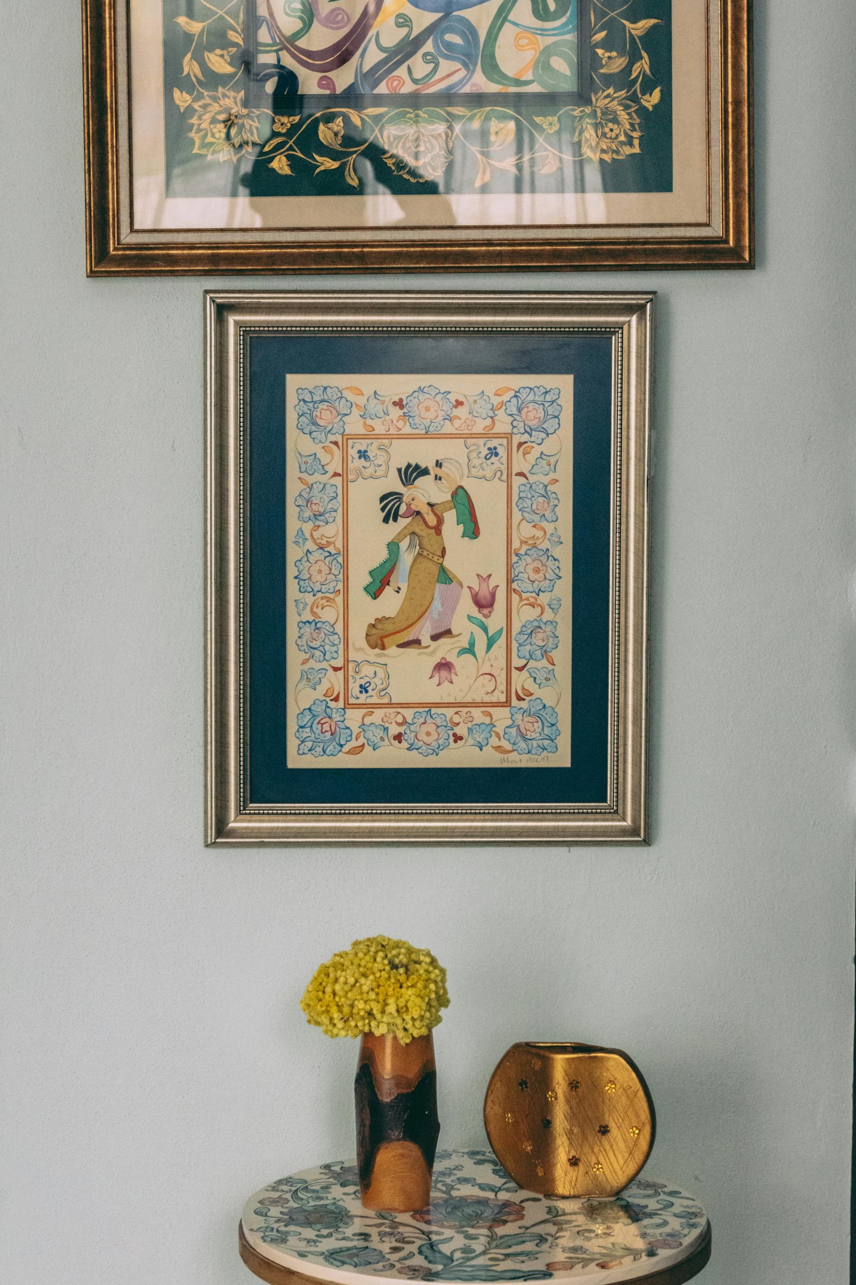 A chic interior with framed art and a decorative table arrangement.