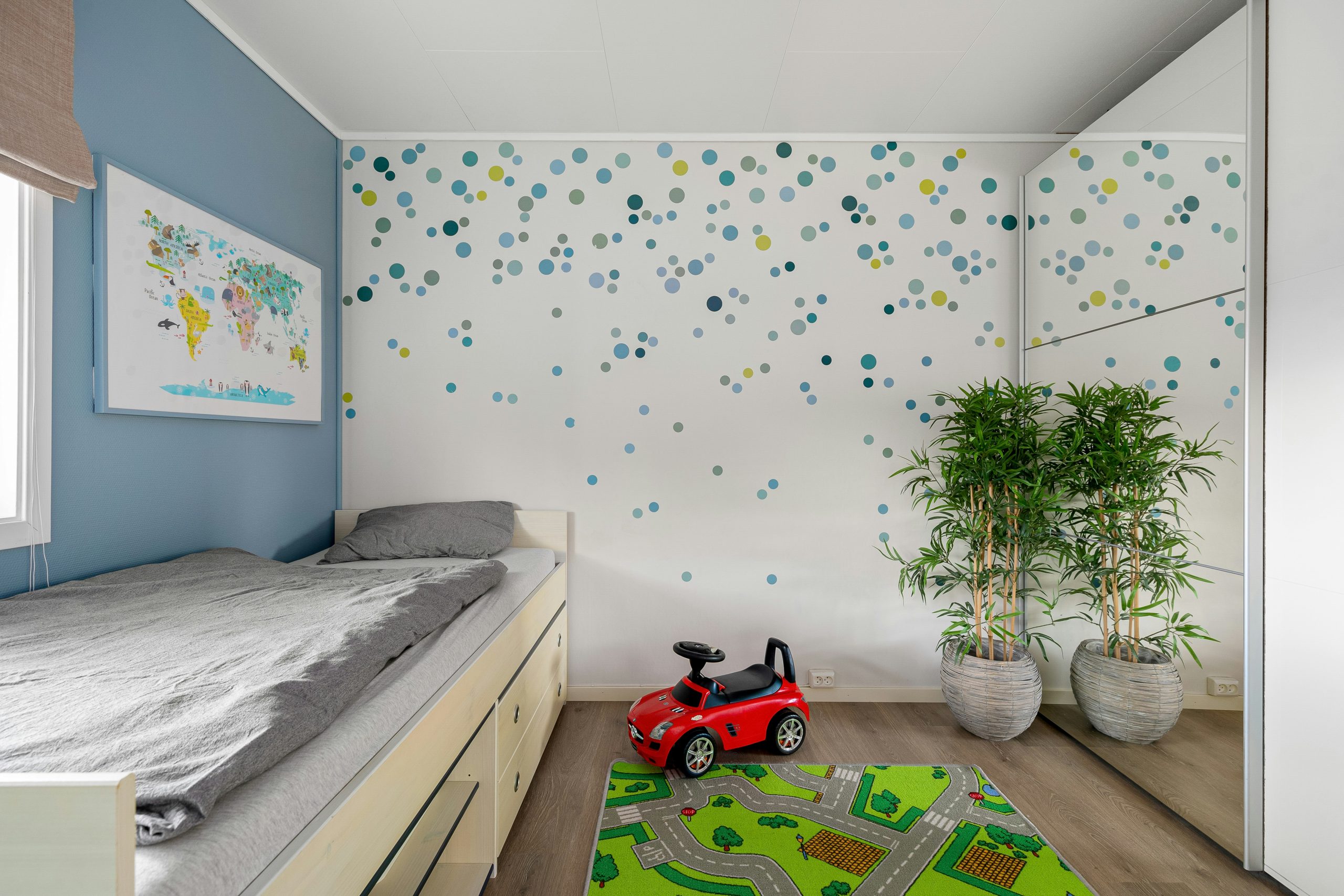 A child's bedroom with a toy car on the floor