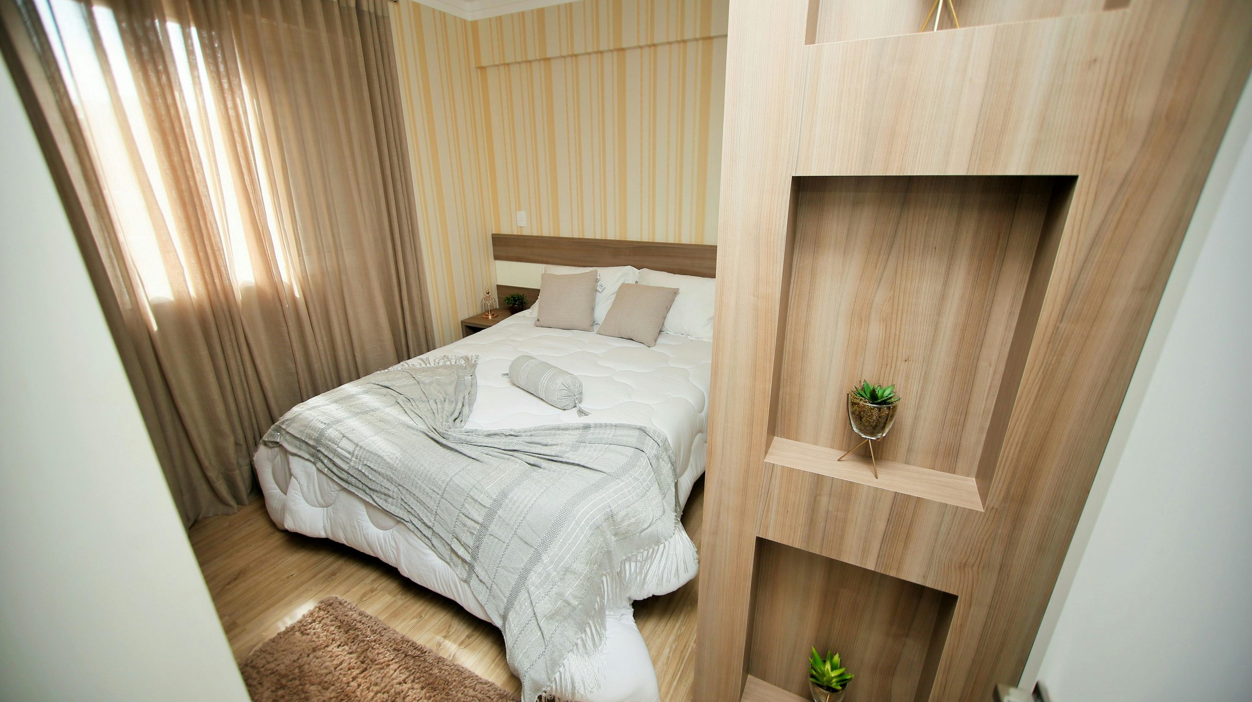 A cozy modern bedroom with neutral tones, soft lighting, and stylish decor for a relaxing ambiance.