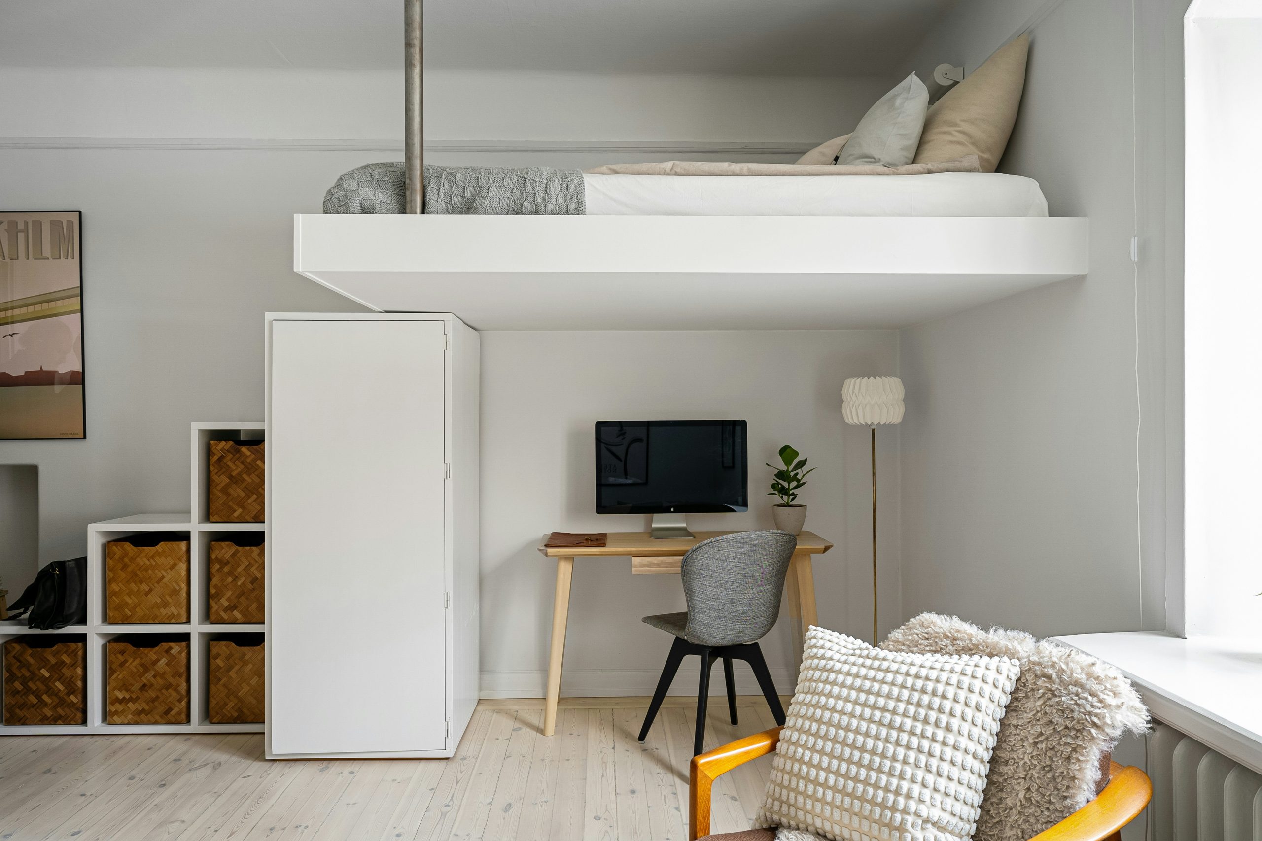 A room with a loft bed and a desk