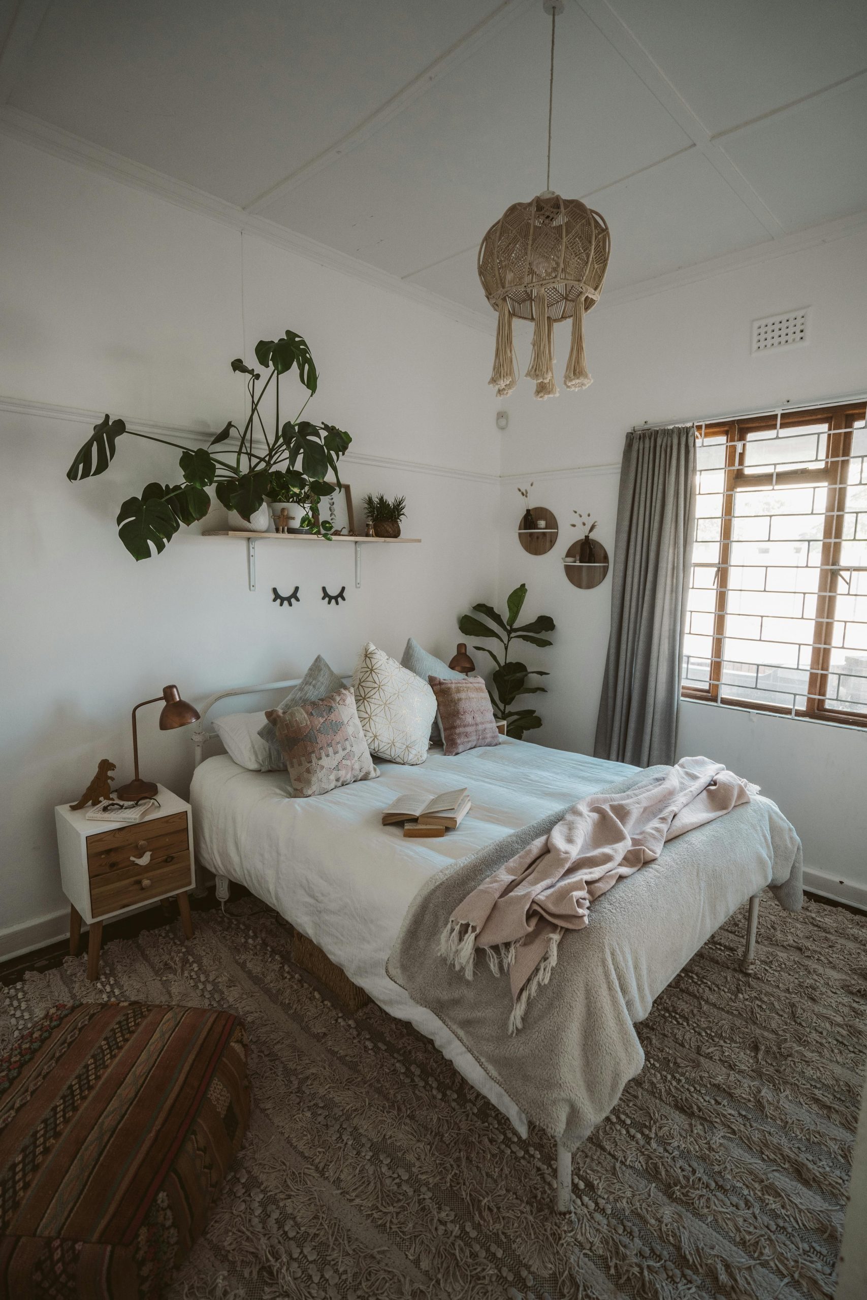 A serene bedroom with natural decor elements, soft lighting, and indoor plants.