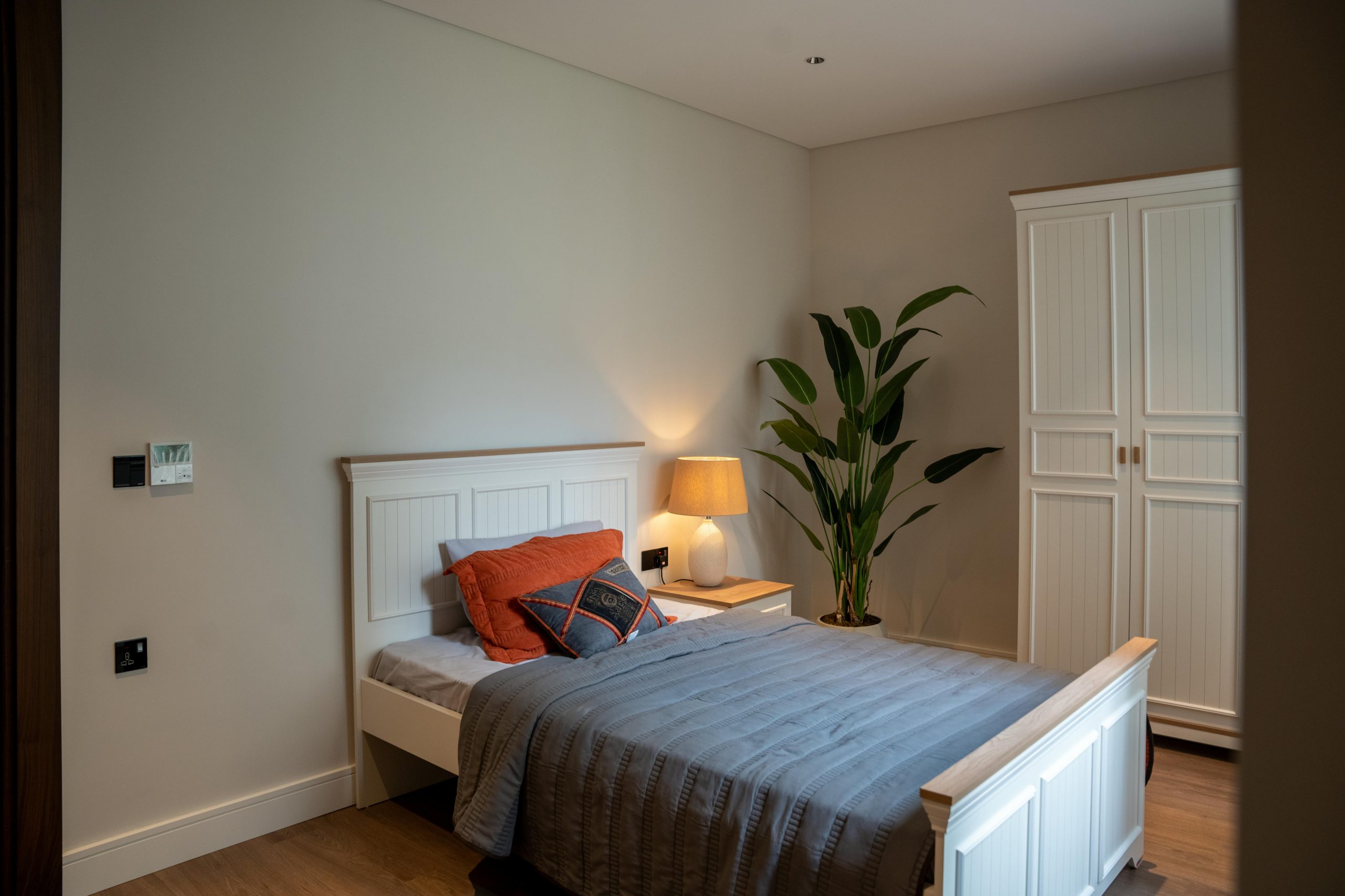 A serene minimalist bedroom featuring a comfortable bed, soft lighting, and modern decor.