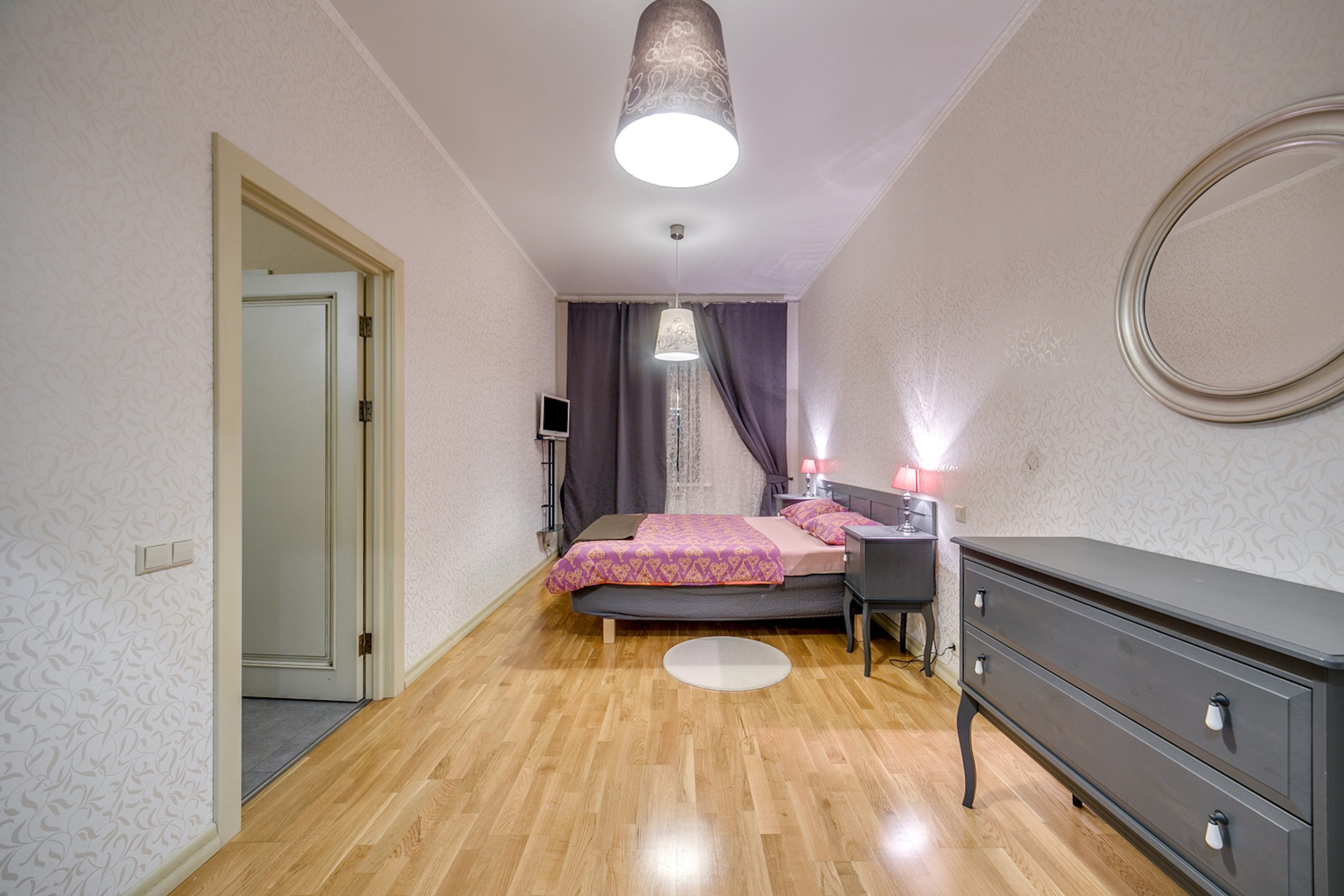 A spacious bedroom featuring stylish decor, soothing lighting, and modern furniture for comfort.