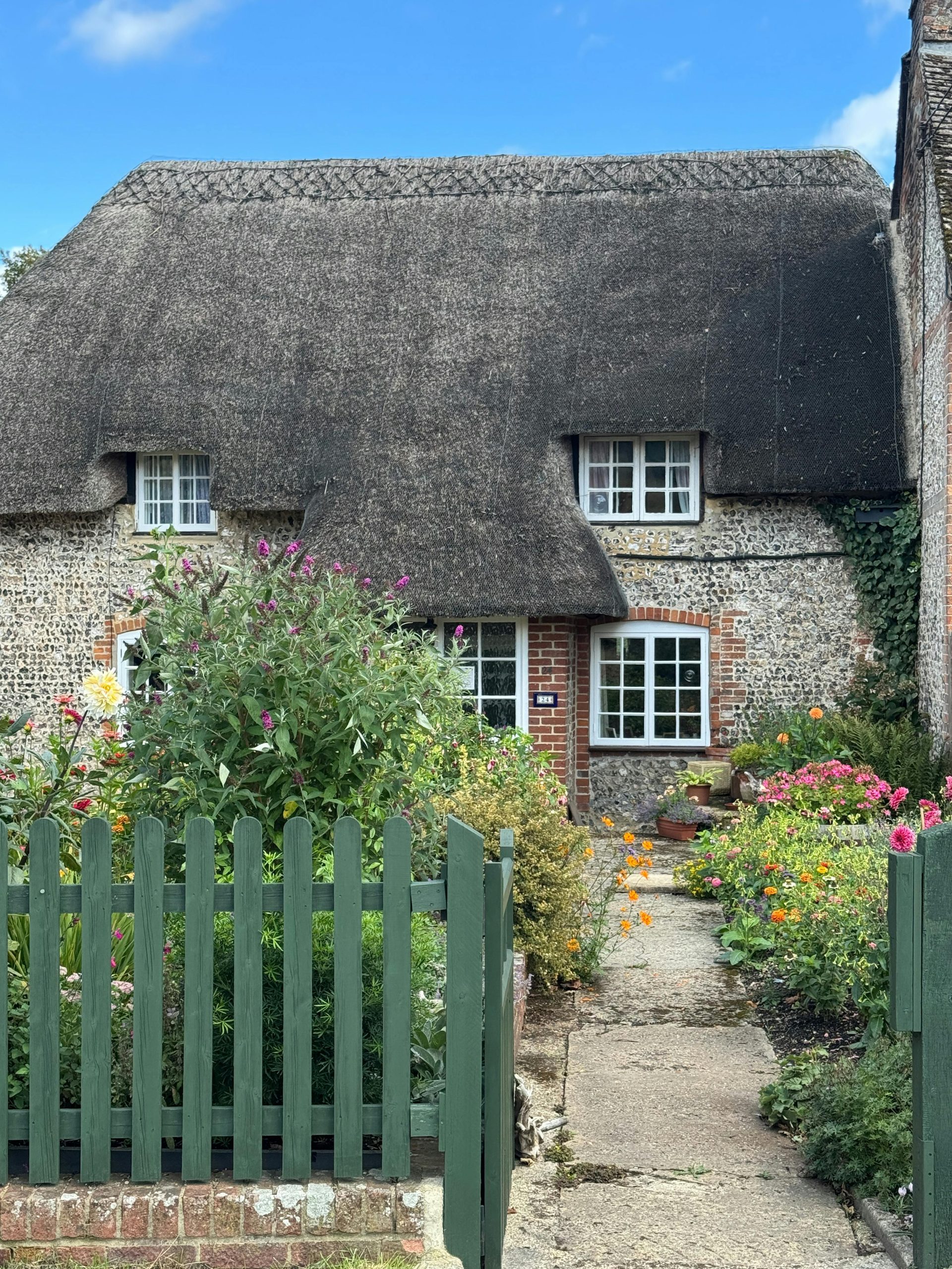 Beautiful thatched-roof cottage with a lush garden in Ludgershall, England.