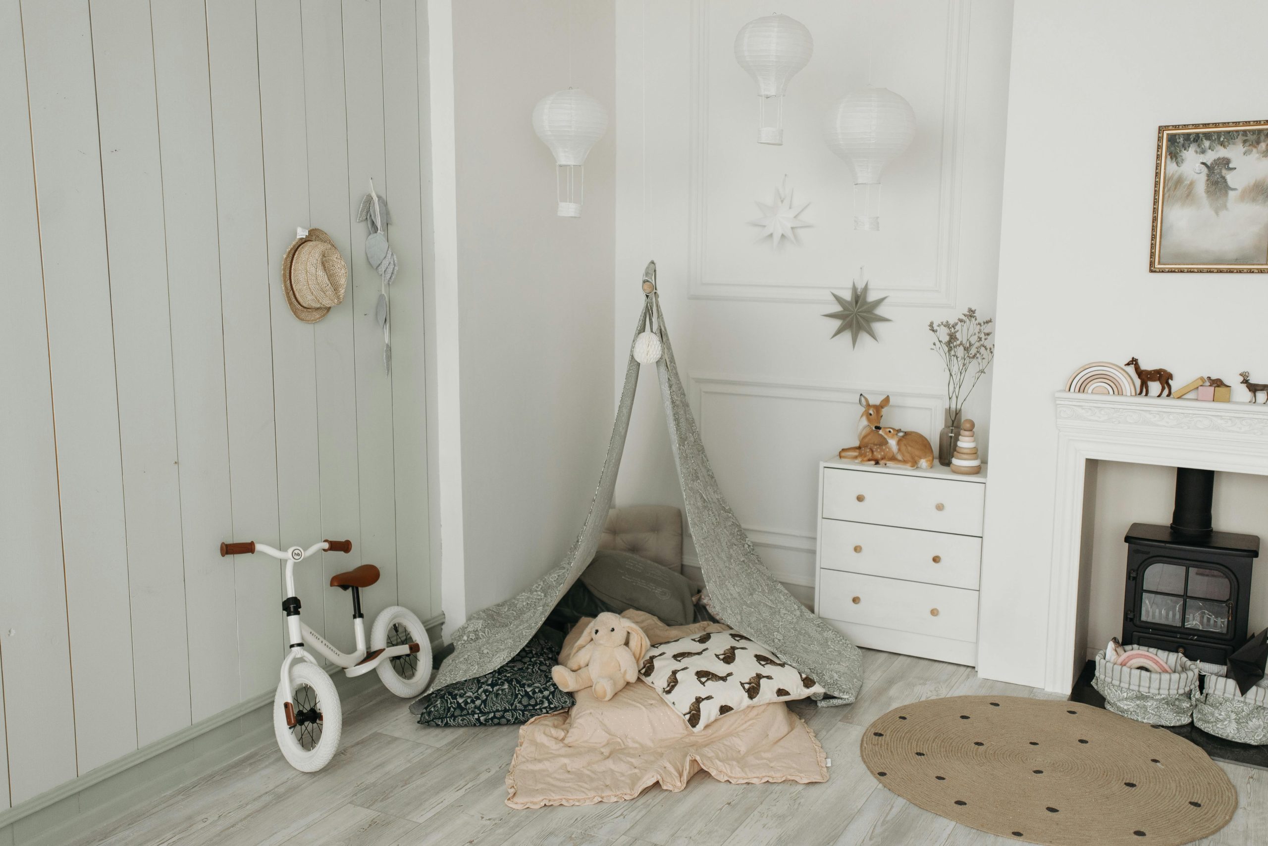 Charming children's room featuring a play tent, balance bike, and cozy interior design.