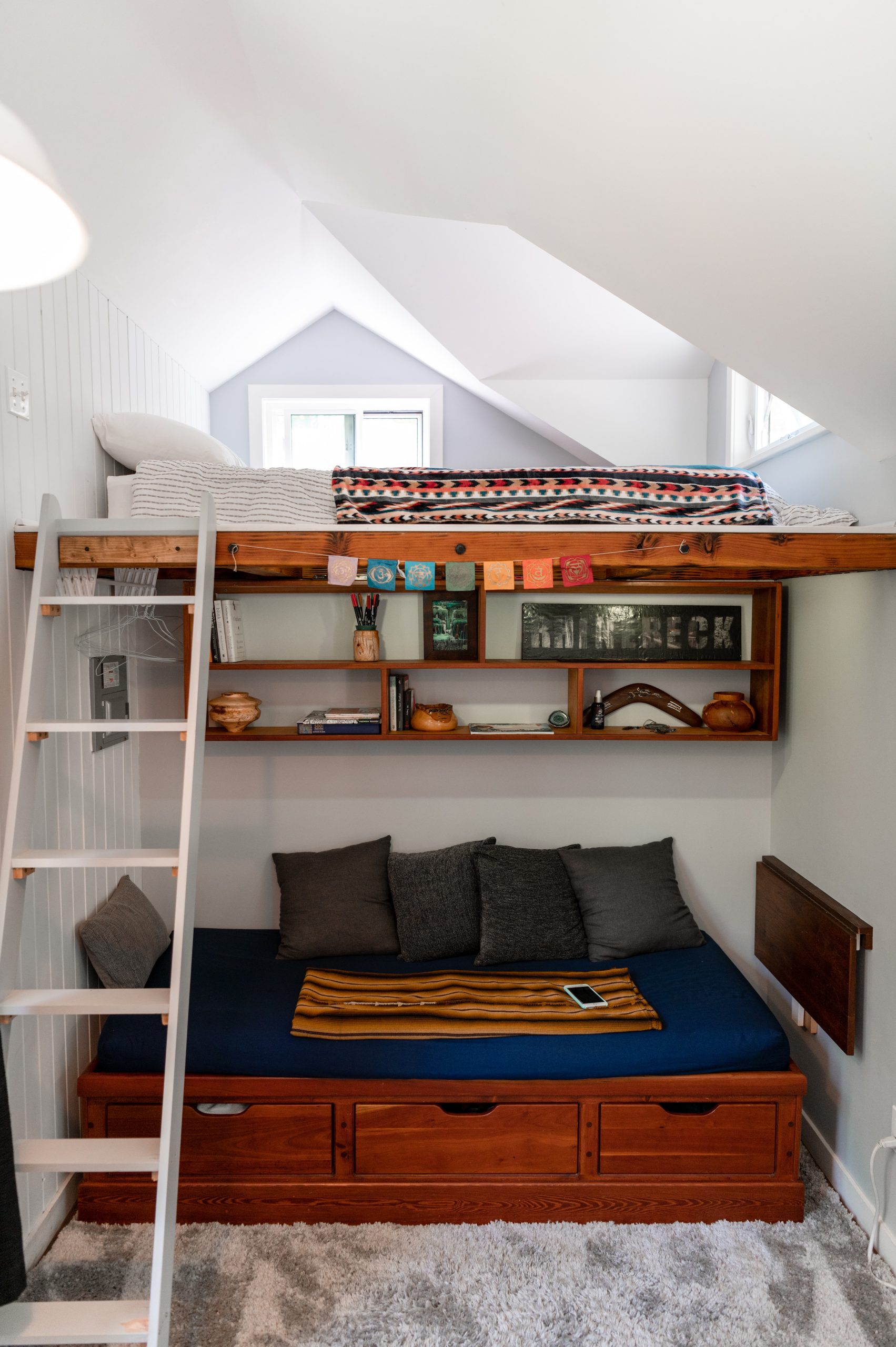 Chic loft bed with ladder in a stylishly decorated modern bedroom, perfect for compact living.
