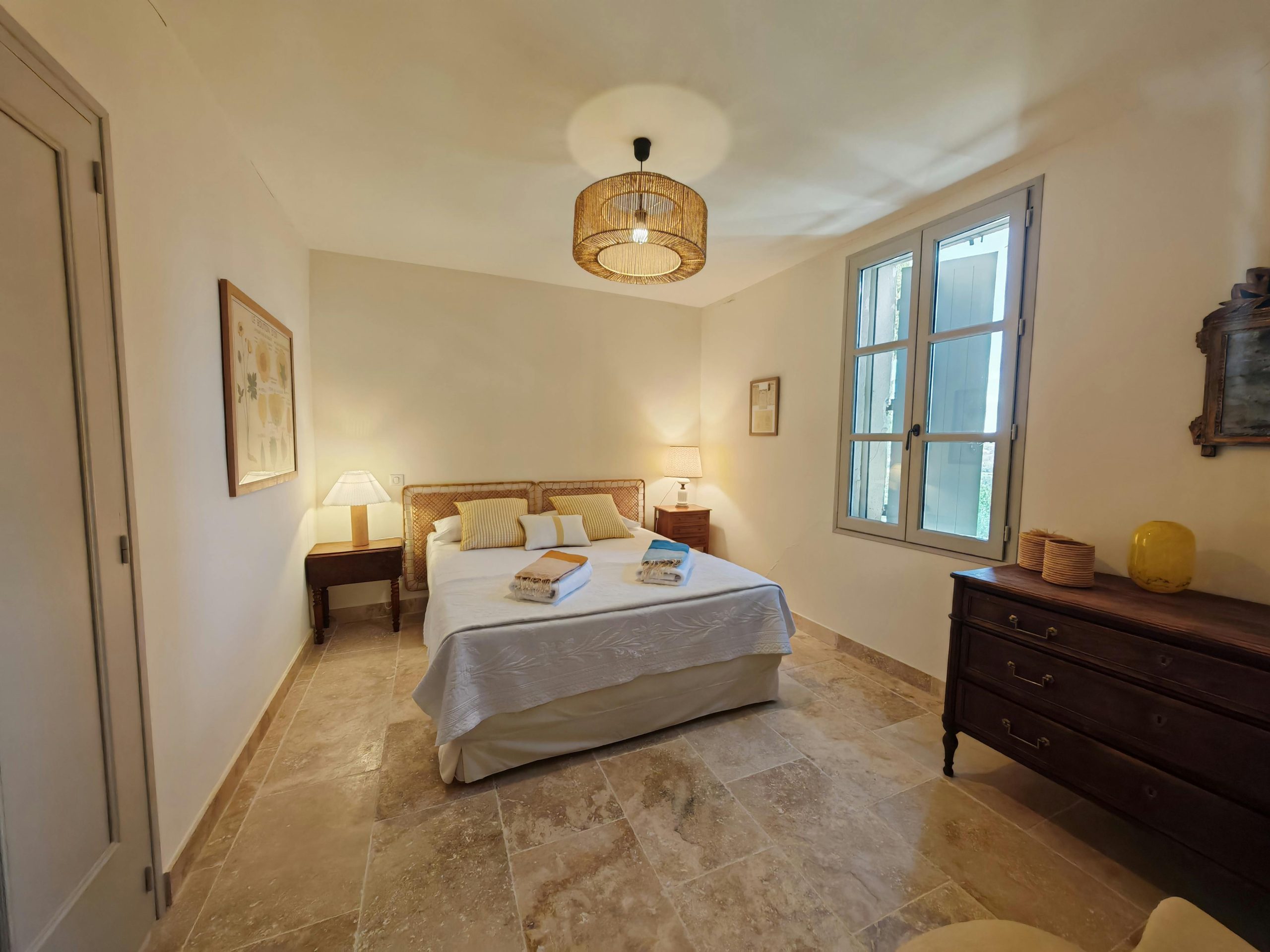 Elegant bedroom with natural light, neutral decor, and comfortable bed.