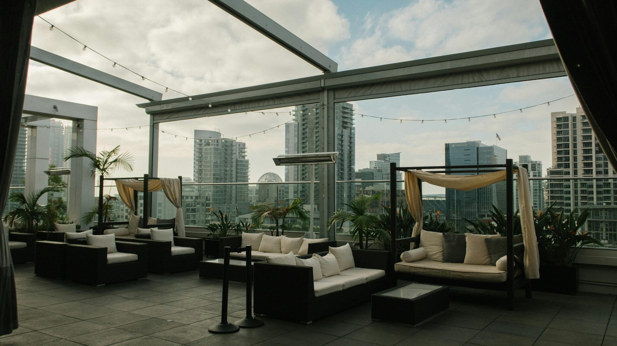 Elegant rooftop patio featuring luxury seating and city skyline backdrop.