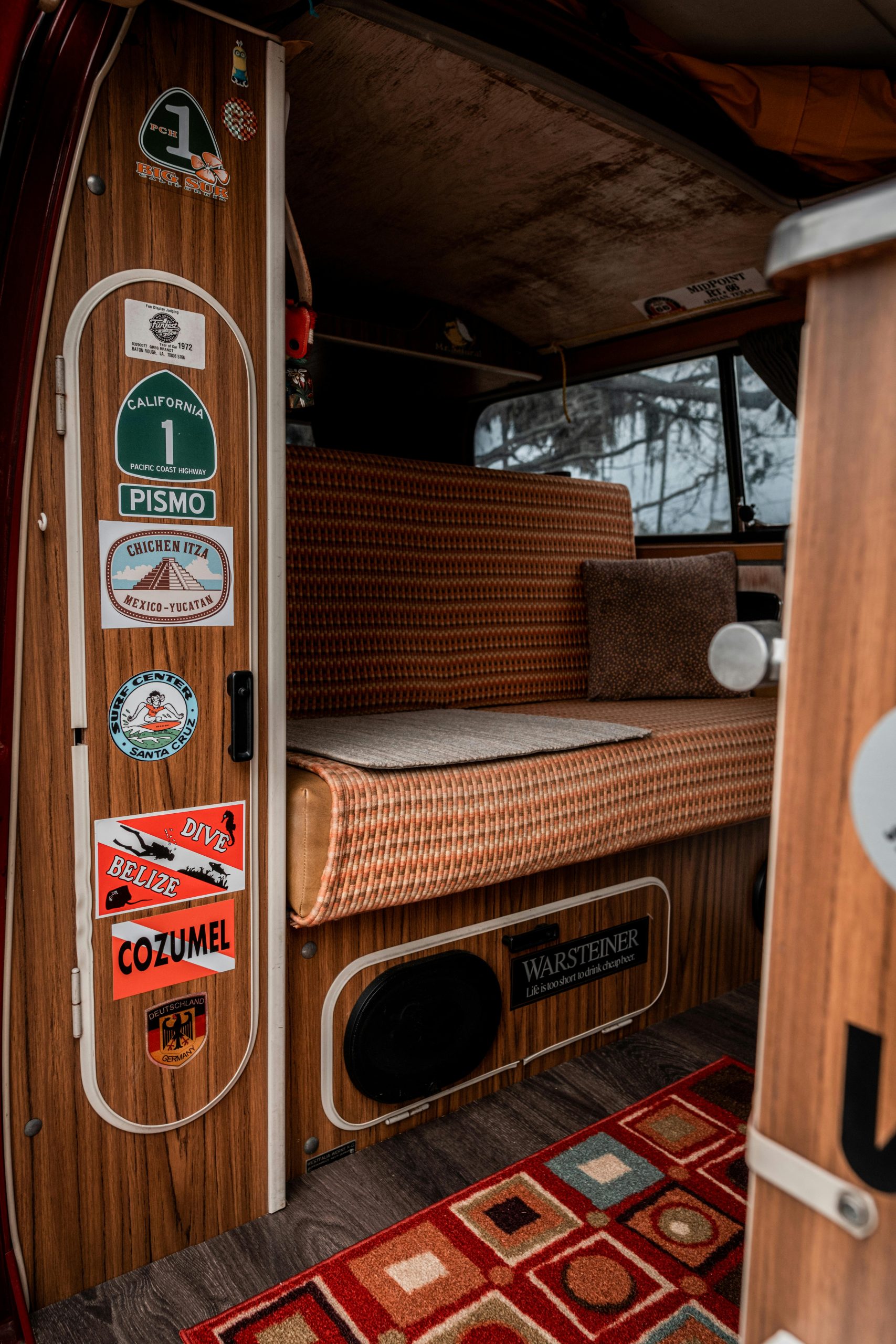 Explore the nostalgic charm of a vintage Volkswagen camper van interior with retro seating and travel stickers.