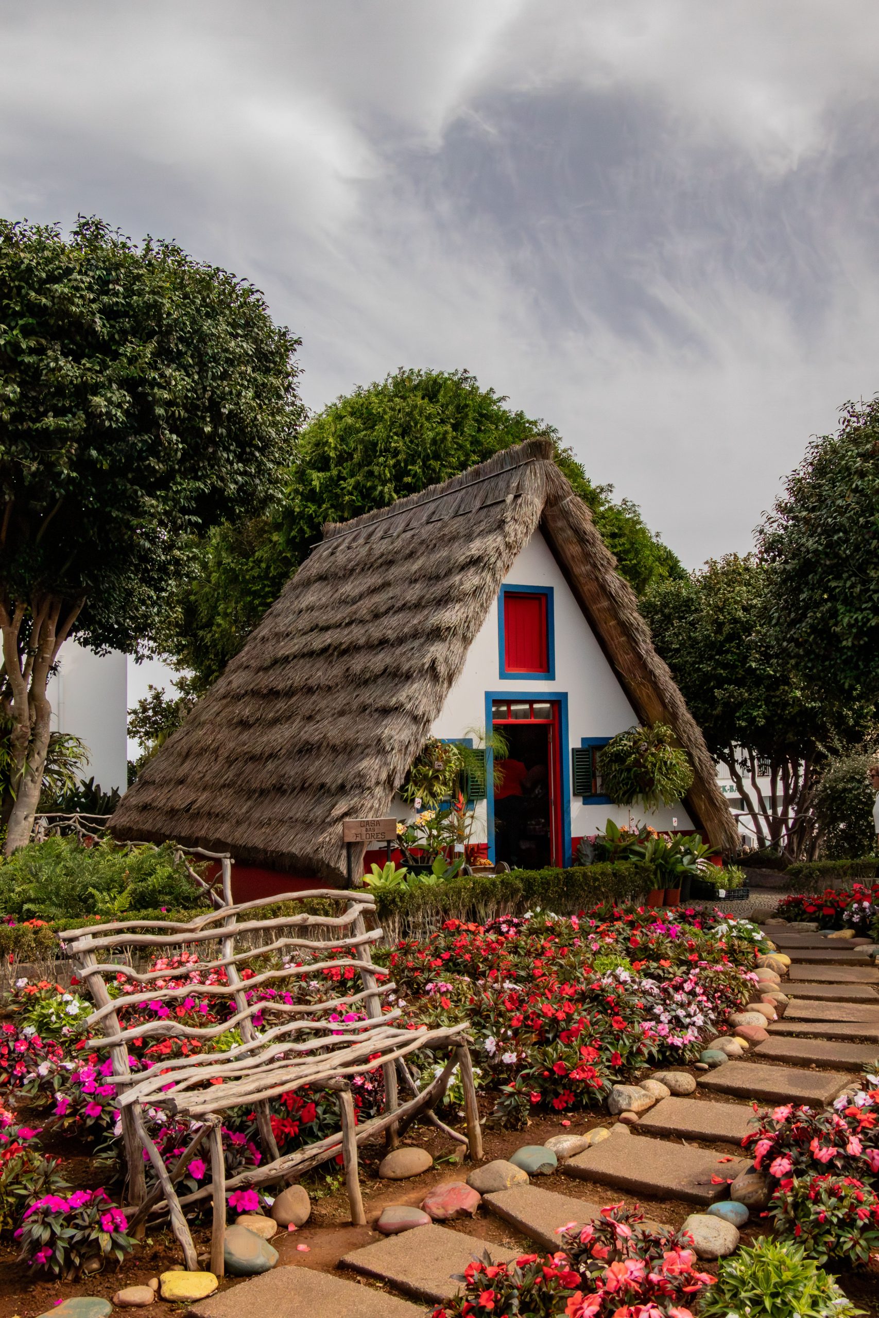 Explore the picturesque A-frame house amidst vibrant gardens in Santana, Madeira, Portugal.