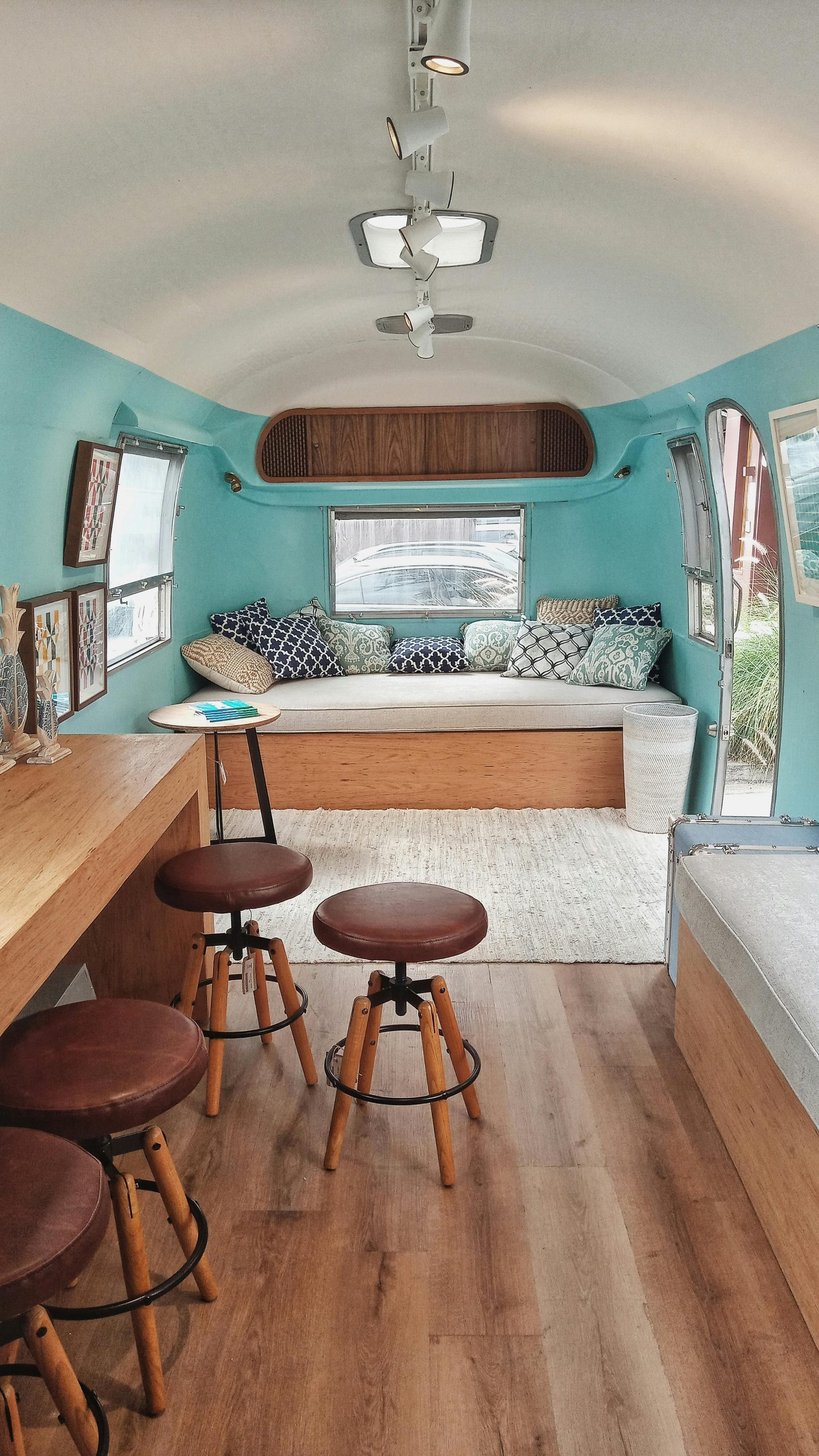 Explore this stylish camper van interior featuring modern design, hardwood flooring, and cozy seating.
