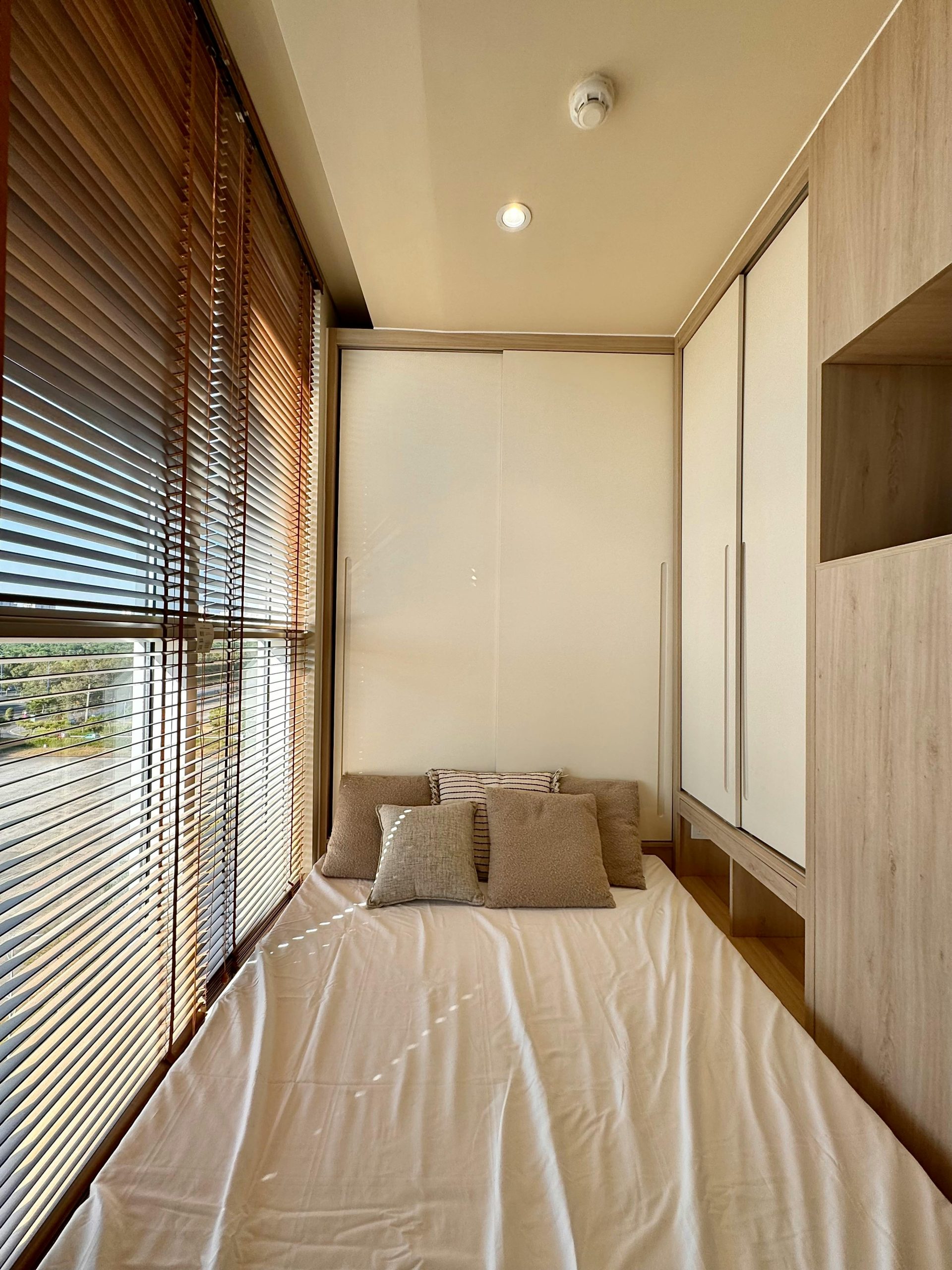 Inviting and sunlit modern bedroom featuring gentle natural light, minimalist decor, and cozy pillows.
