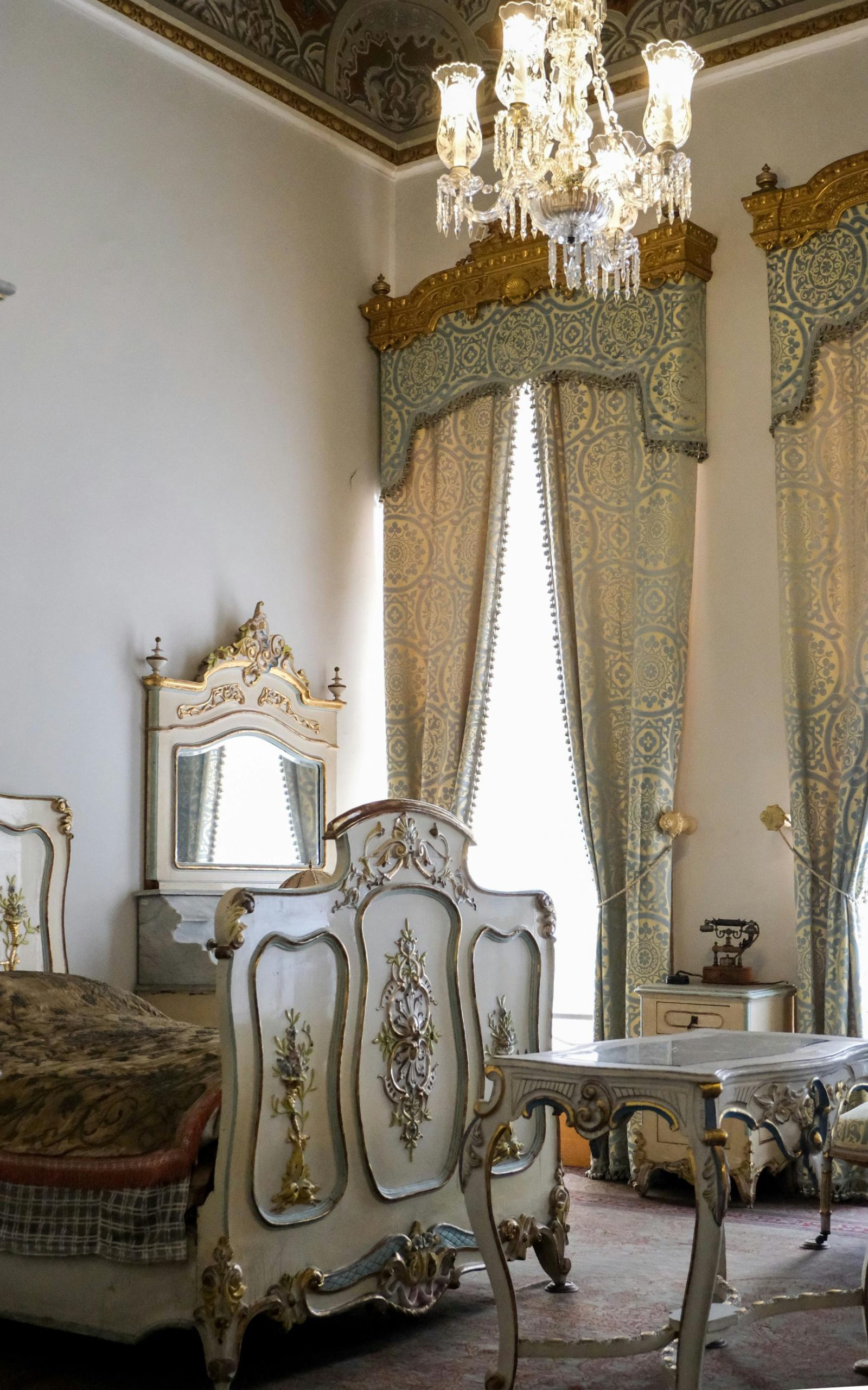 Luxurious vintage bedroom with exquisite furnishings and chandeliers, perfect for elegance and style.