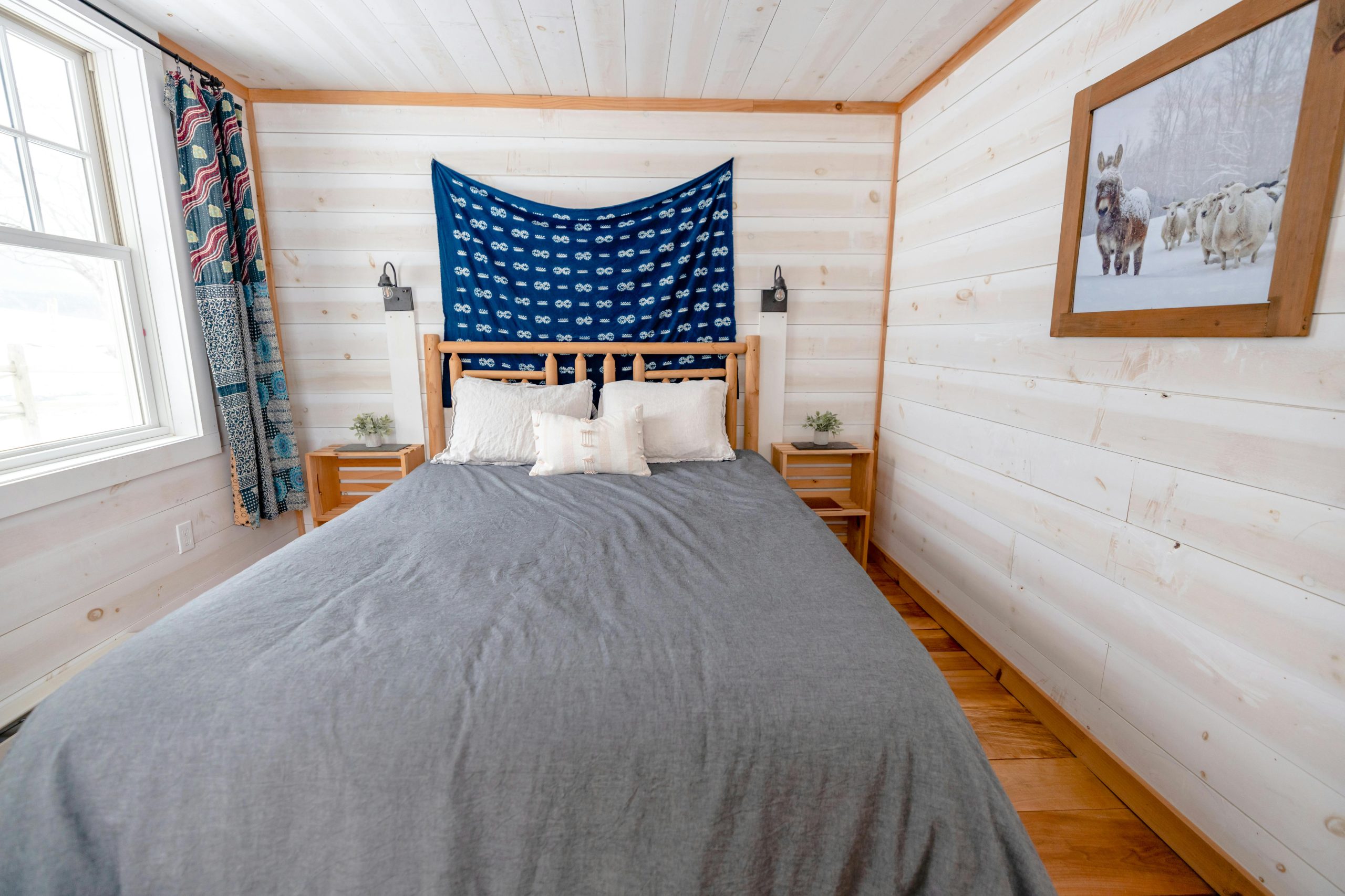 Minimalist bedroom with rustic decor, wooden walls, and cozy bedding.