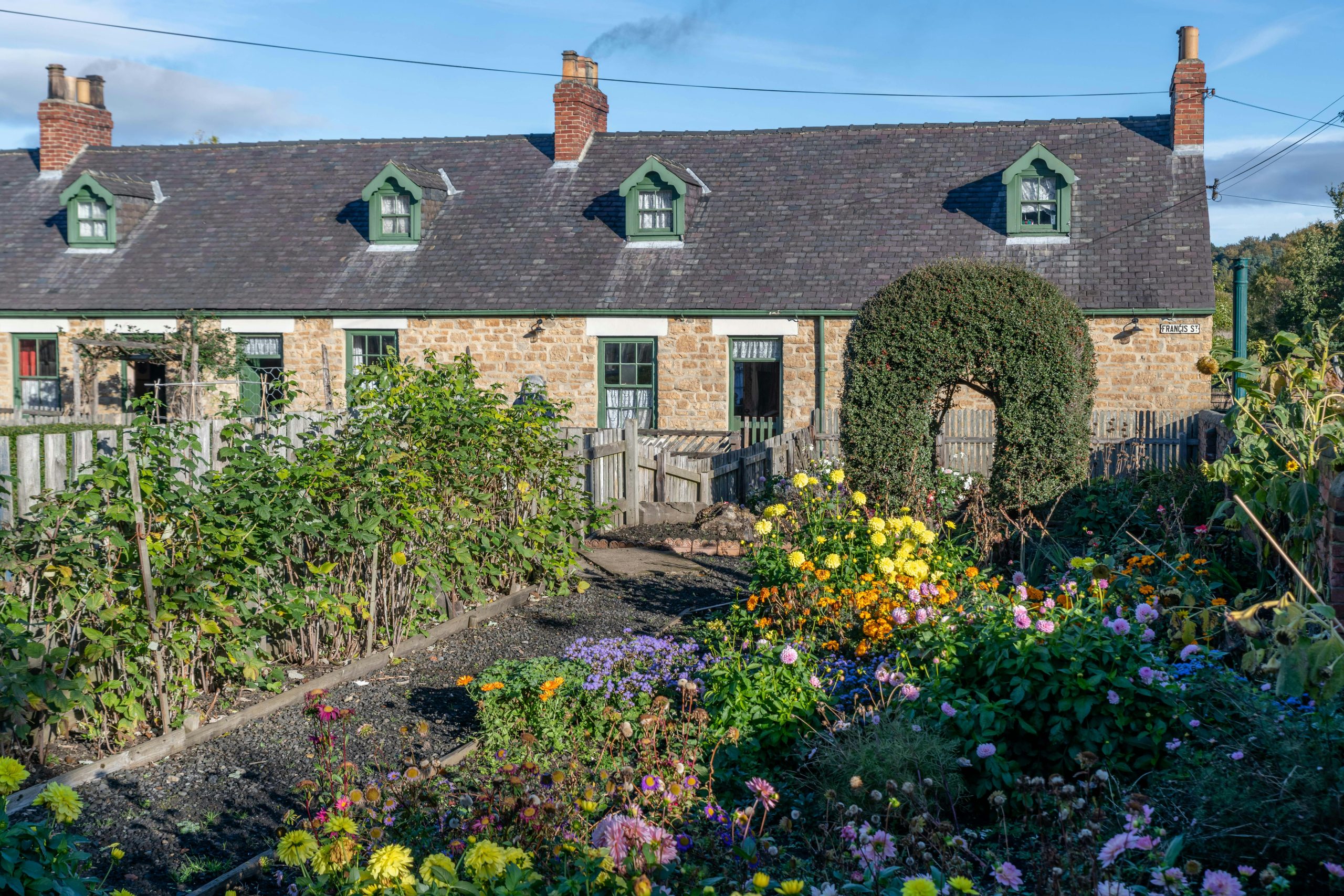 Quaint cottage in Beamish, England, surrounded by a vibrant flower garden.