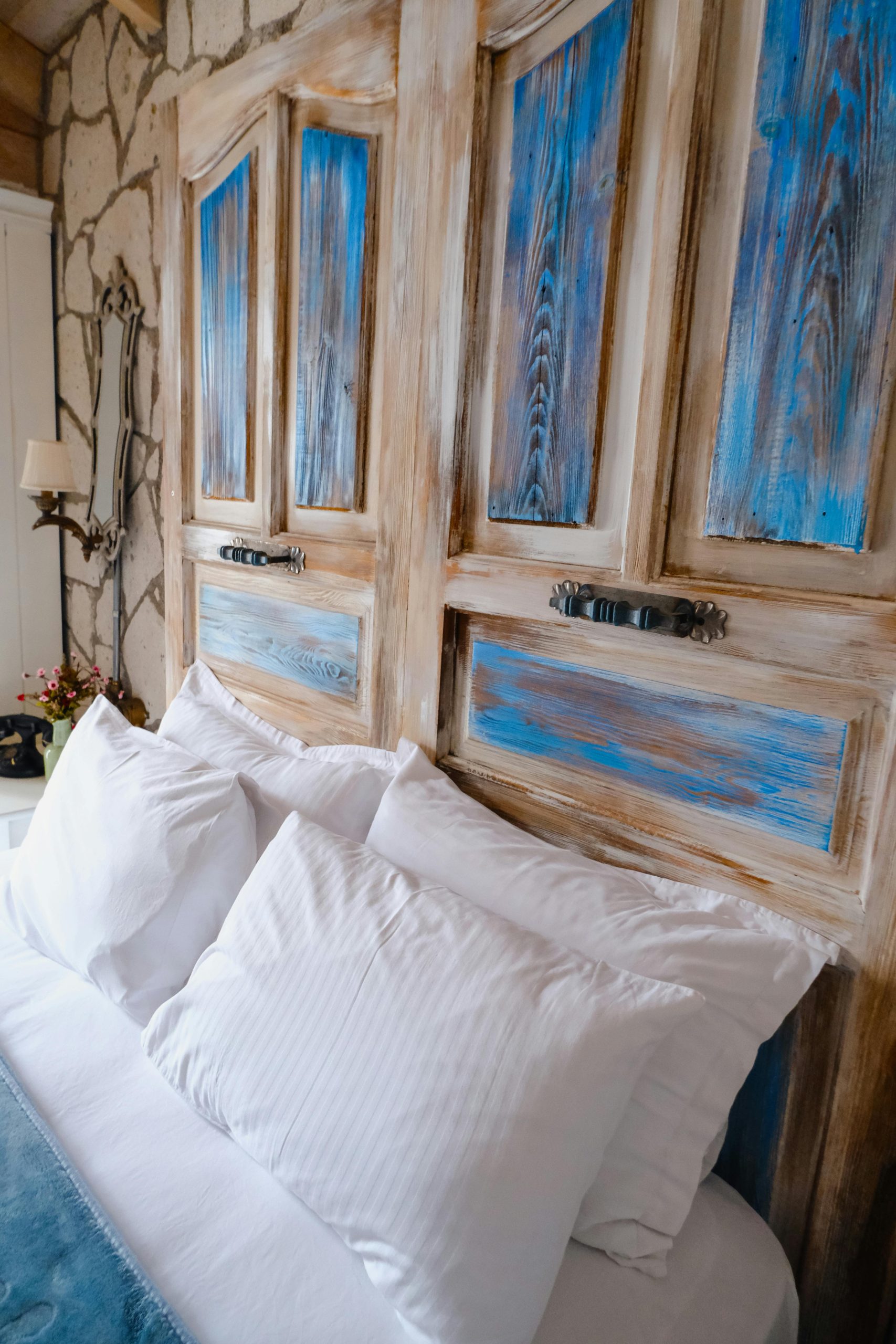Rustic bedroom with vintage wooden headboard and tranquil decor, capturing a cozy ambiance.