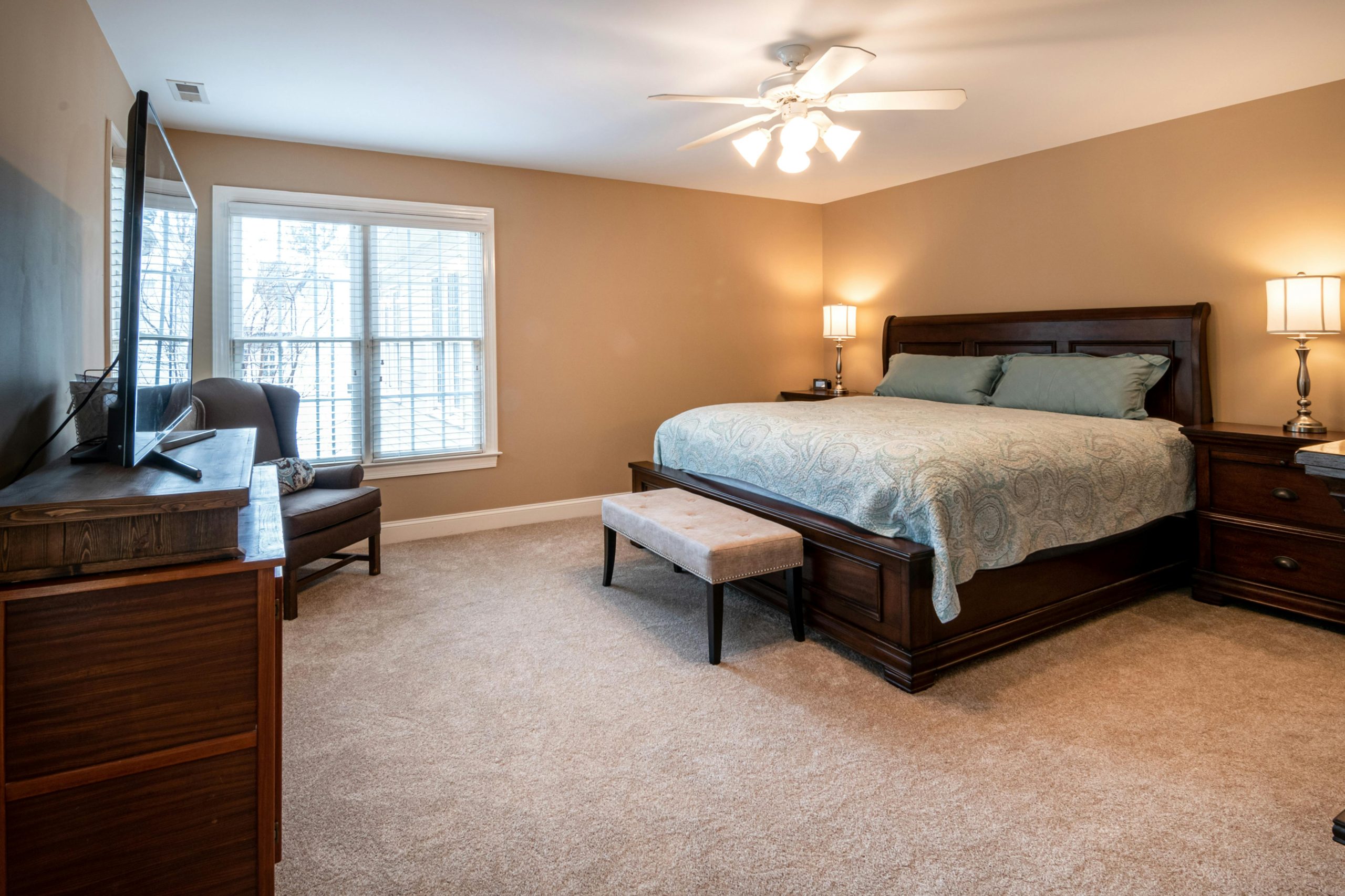 Spacious bedroom with elegant furniture and warm lighting, showcasing modern interior design.